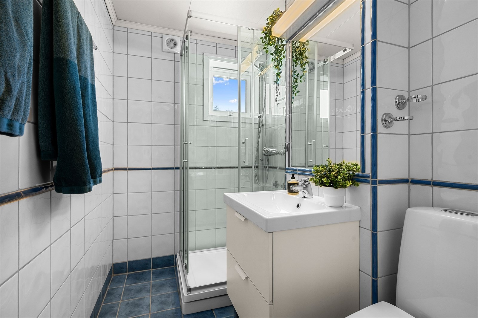 Badet er på 3m² og innehar gulvvarme. Videre er badet utstyrt med dusjkabinett, toalett og servant med skap. Galleribilde