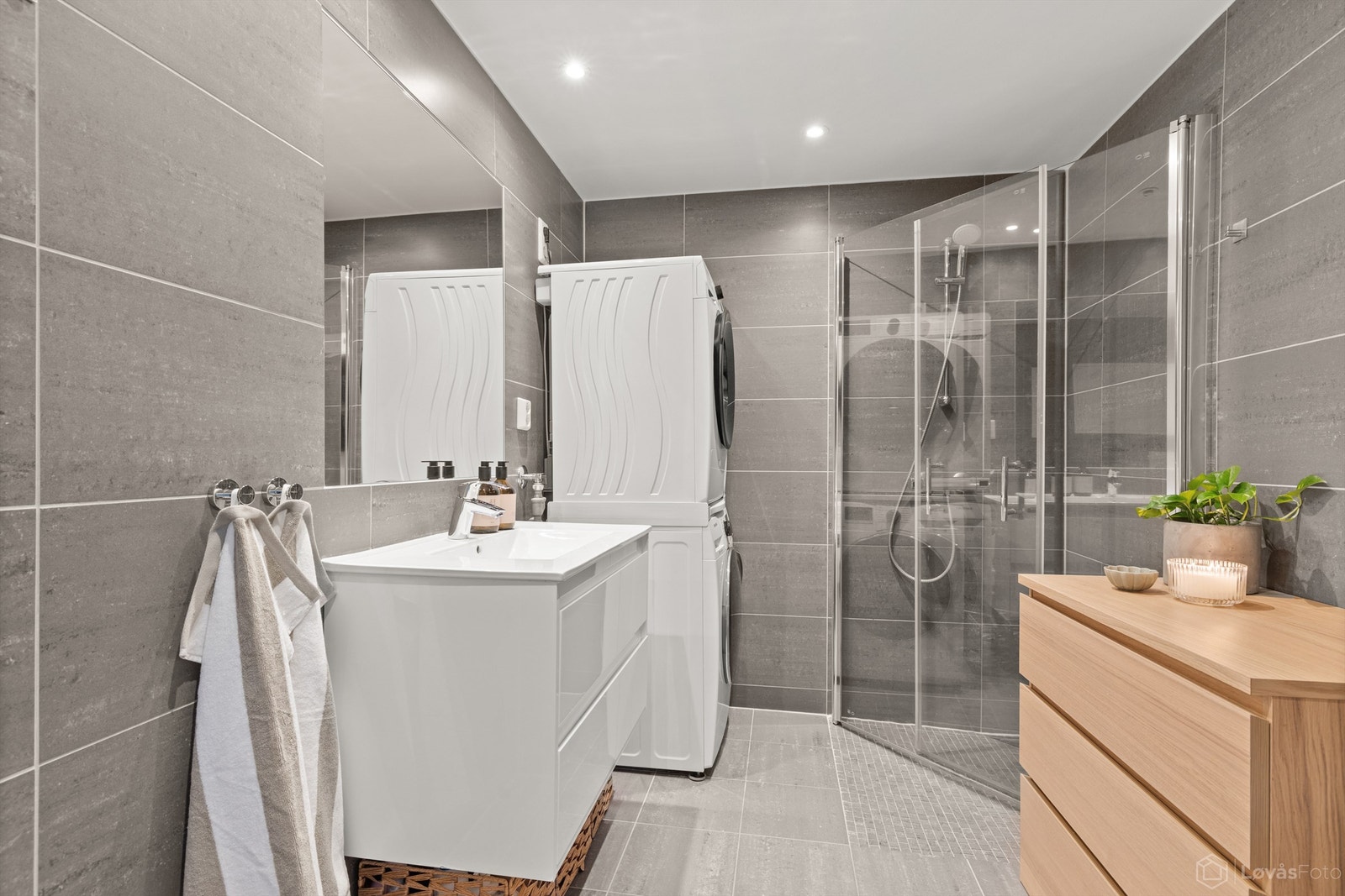 Badet er praktisk innredet med dusjhjørne med innfellbare dører og opplegg for vaskemaskin. Galleribilde
