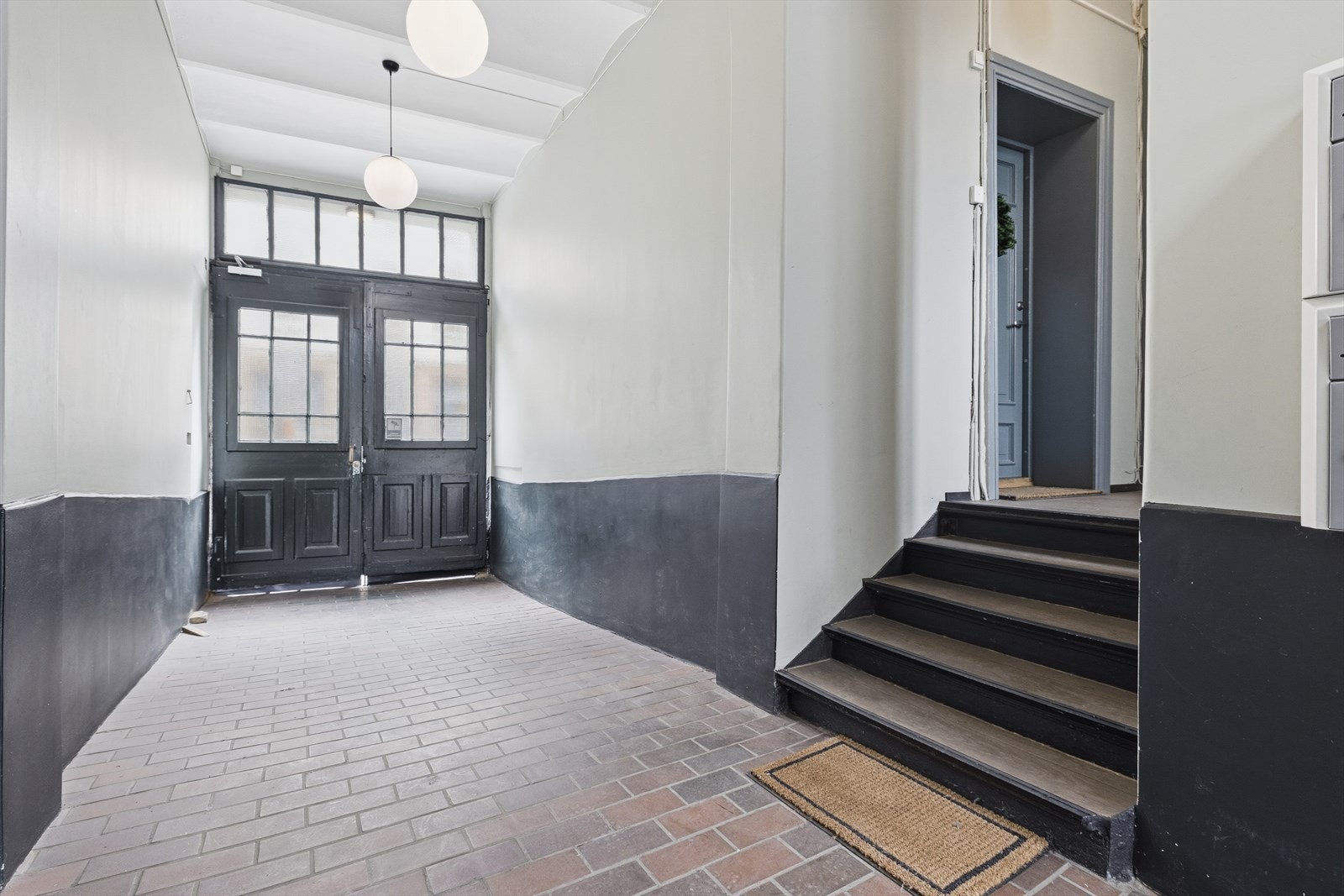 Hyggelig og romslig inngangsparti, med boligens blå ytterdør avbildet. Galleribilde