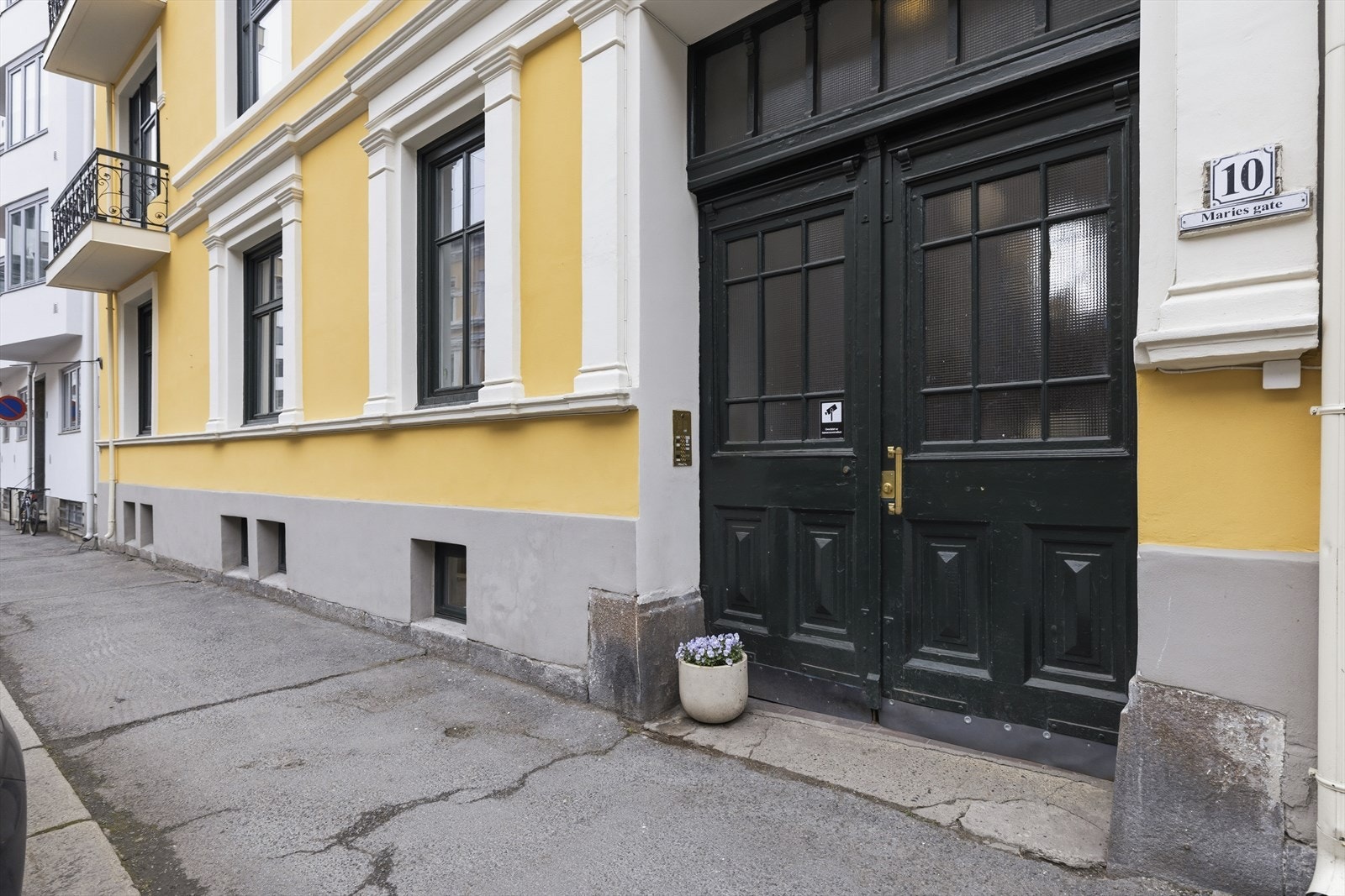 Bygget har et hyggelig og innbydende inngangsparti, hvor boligens vinduer ligger til venstre for inngangsdøren. Galleribilde