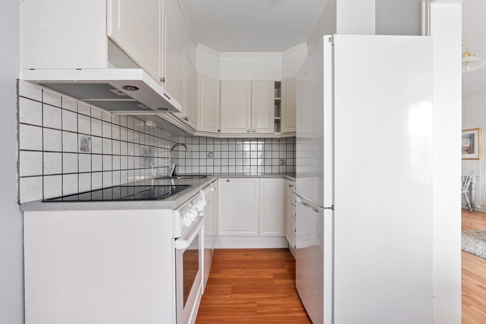 Kjøkken med mye skap- og benkeplass for praktisk oppbevaring og gode arbeidsflater.