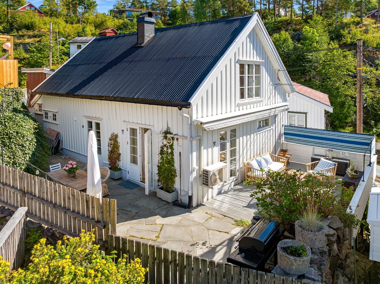 En oversikt over den private og solrike uteplassen med både treterrasse og skifer. Galleribilde