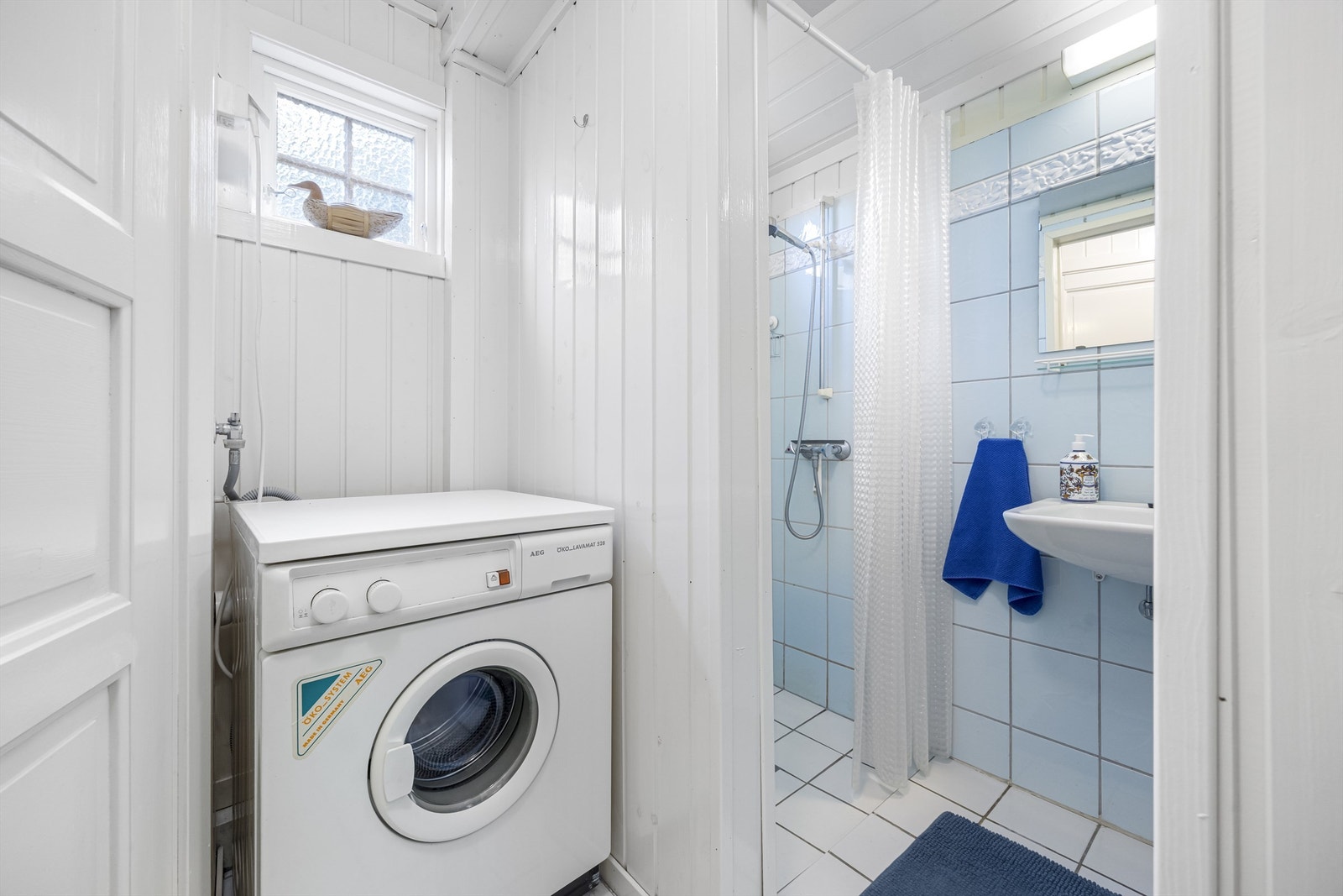 Badet er praktisk innredet med dusjnisje og opplegg for vaskemaskin. Galleribilde