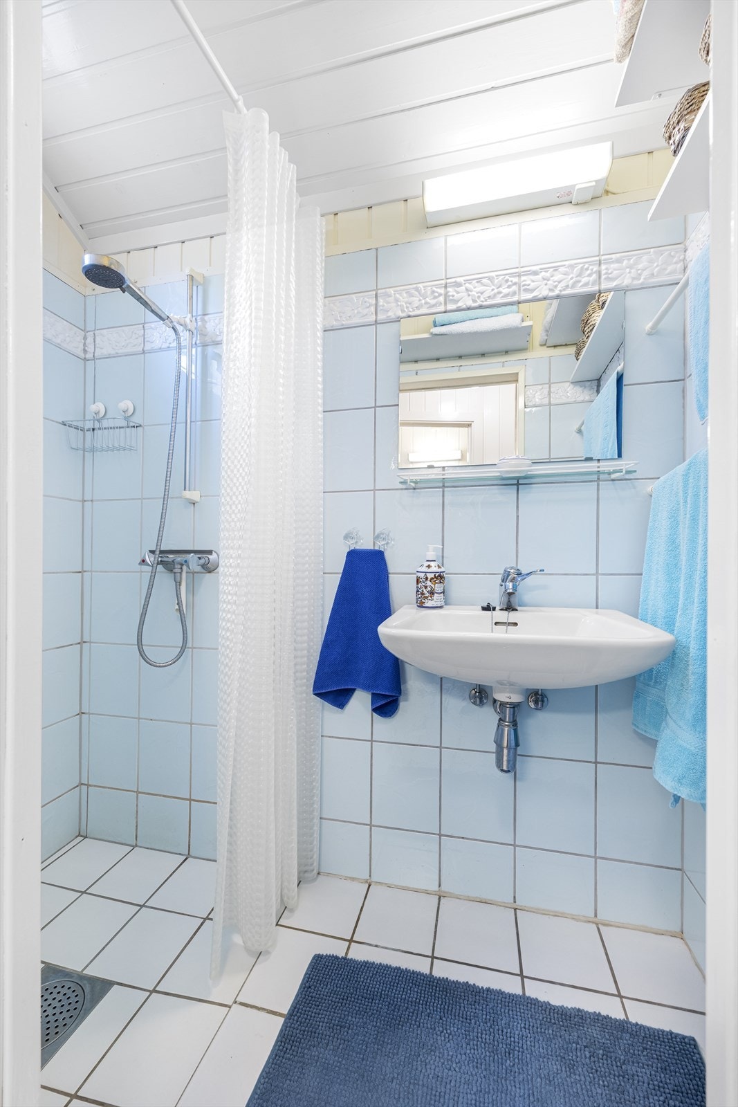 Badet i hovedetasjen har flislagt gulv med varmekabler og fliser i dusjsonen. Galleribilde