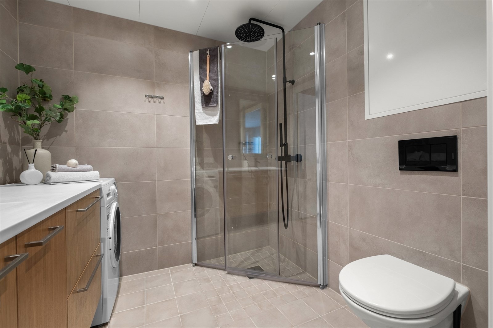 Badet er utstyrt med vegghengt toalett, dusjvegger i glass og servantinnredning. Galleribilde