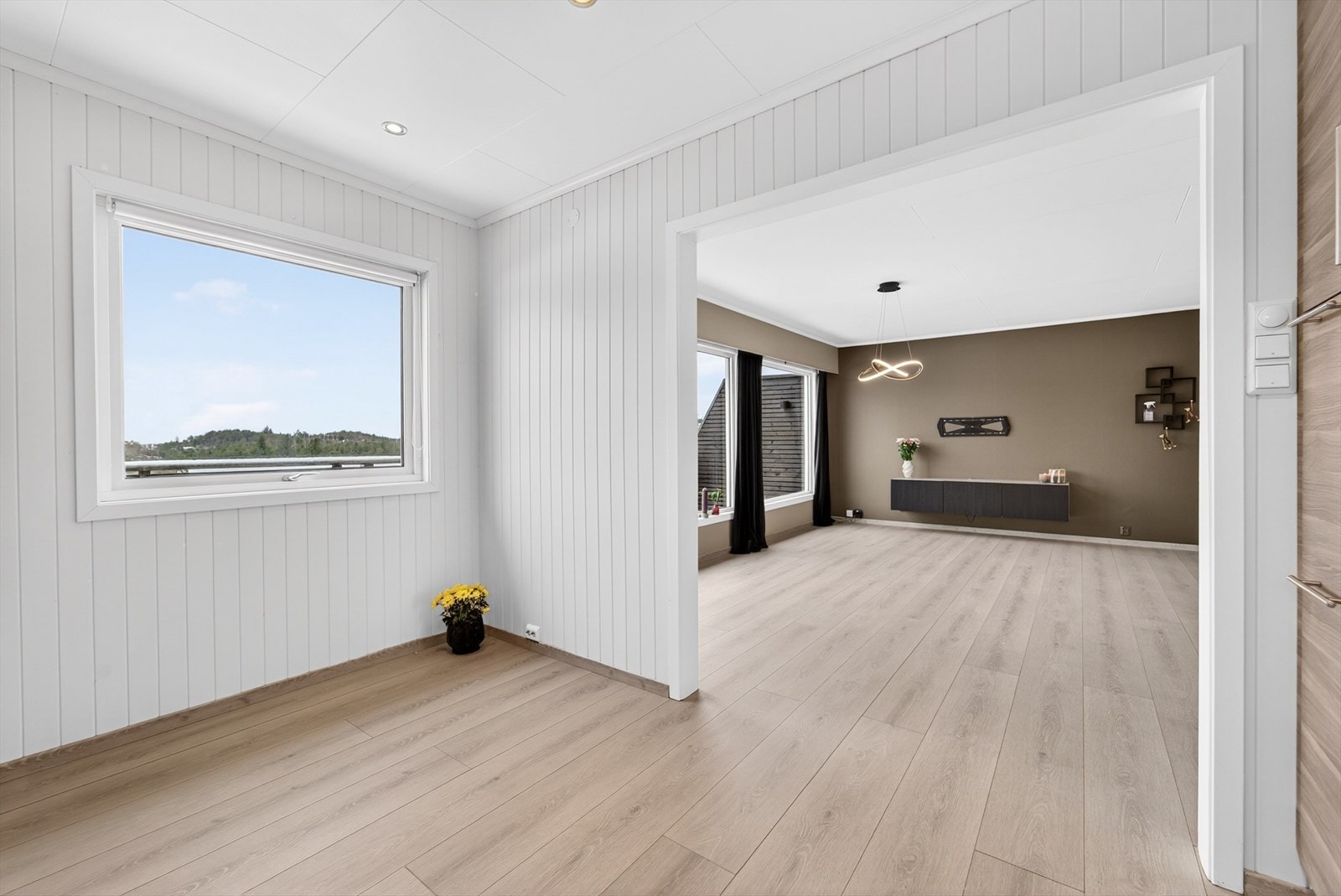 Åpen løsning mellom kjøkken og stue, med en naturlig avgrensning. Galleribilde
