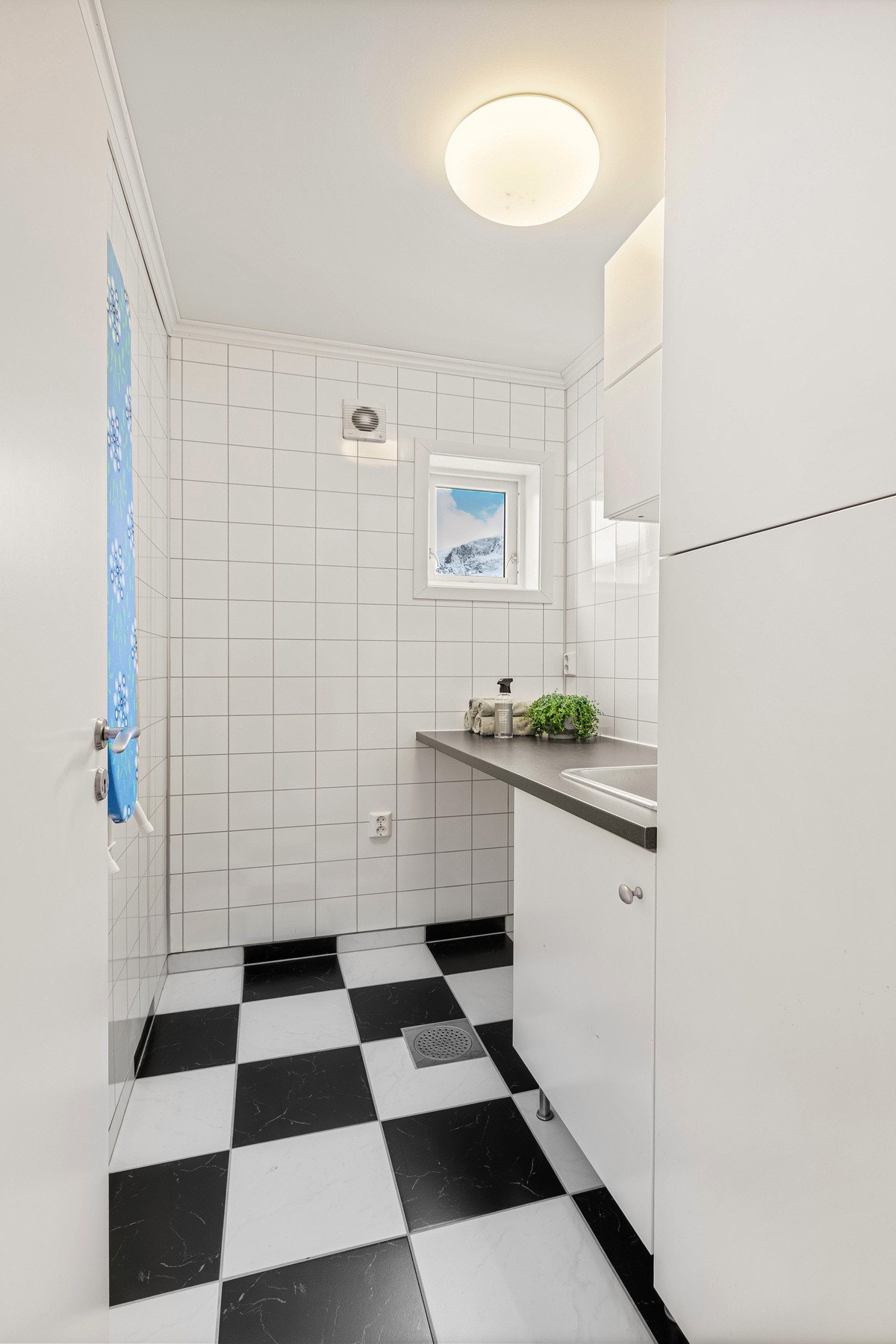 Separat vaskerom med innredning med servant og opplegg for vaskemaskin/tørketrommel. Galleribilde