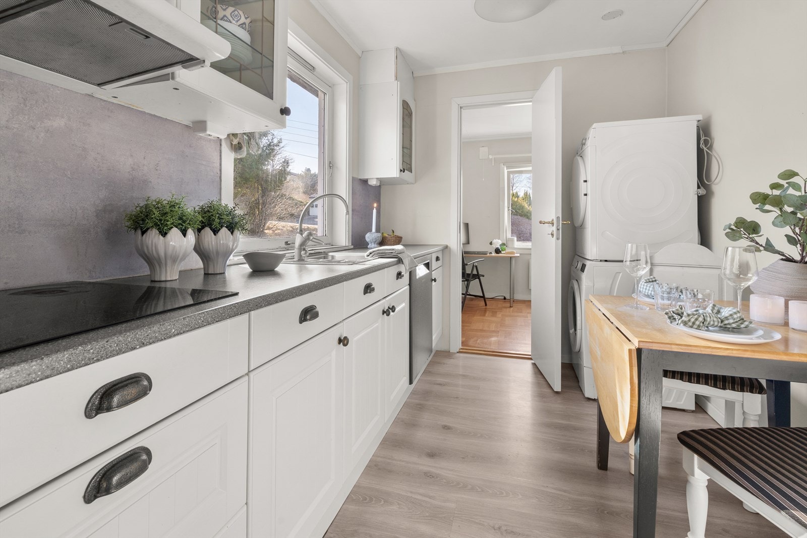 Vi går så tilbake inn og videre til kjøkkenet, som fremstår lyst og moderne med stilrene, lyse fronter. Galleribilde