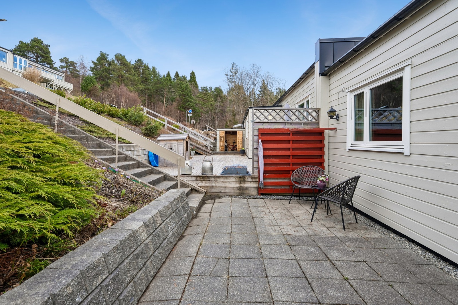 Uteområdet mot nord er steinbelagt og har fin trapp ned til bolig Galleribilde