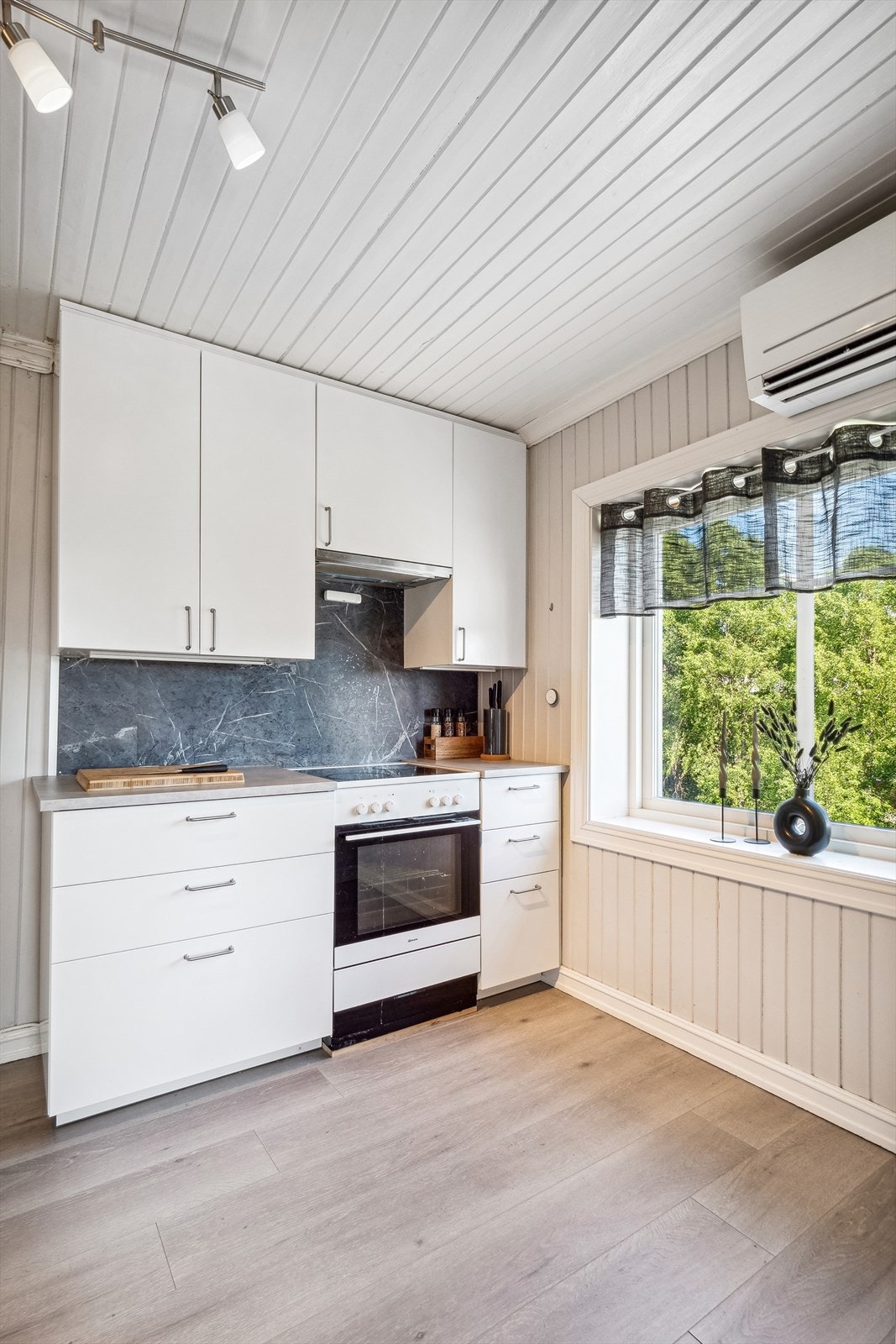 Kjøkken i 2. etasje i hvit glatt stil. Kitchenboard mellom over- og underskap. Galleribilde