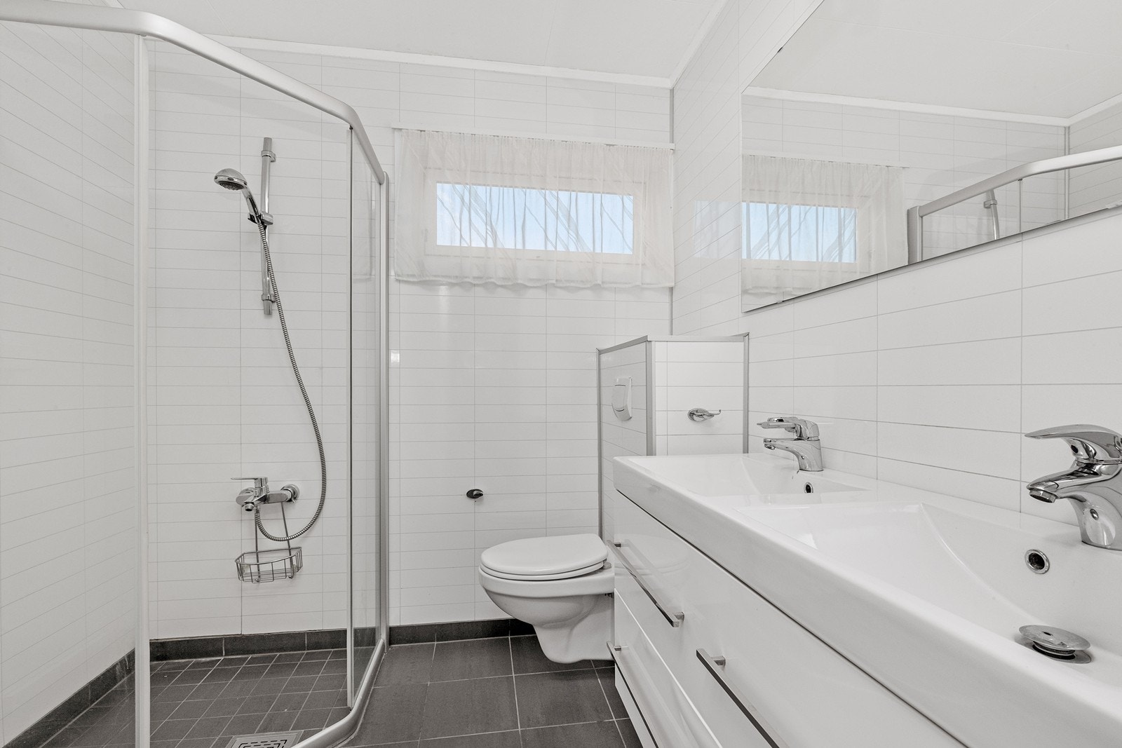 Hovedbadet i første etasje har dobbel servant, dusjhjørne og vegghengt wc.. Galleribilde