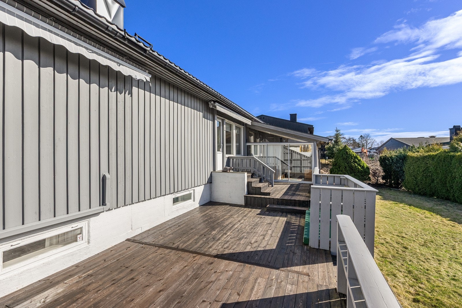 Terrassen strekker seg langs store deler av husets langside. Overbygget del med skyvedører. Galleribilde