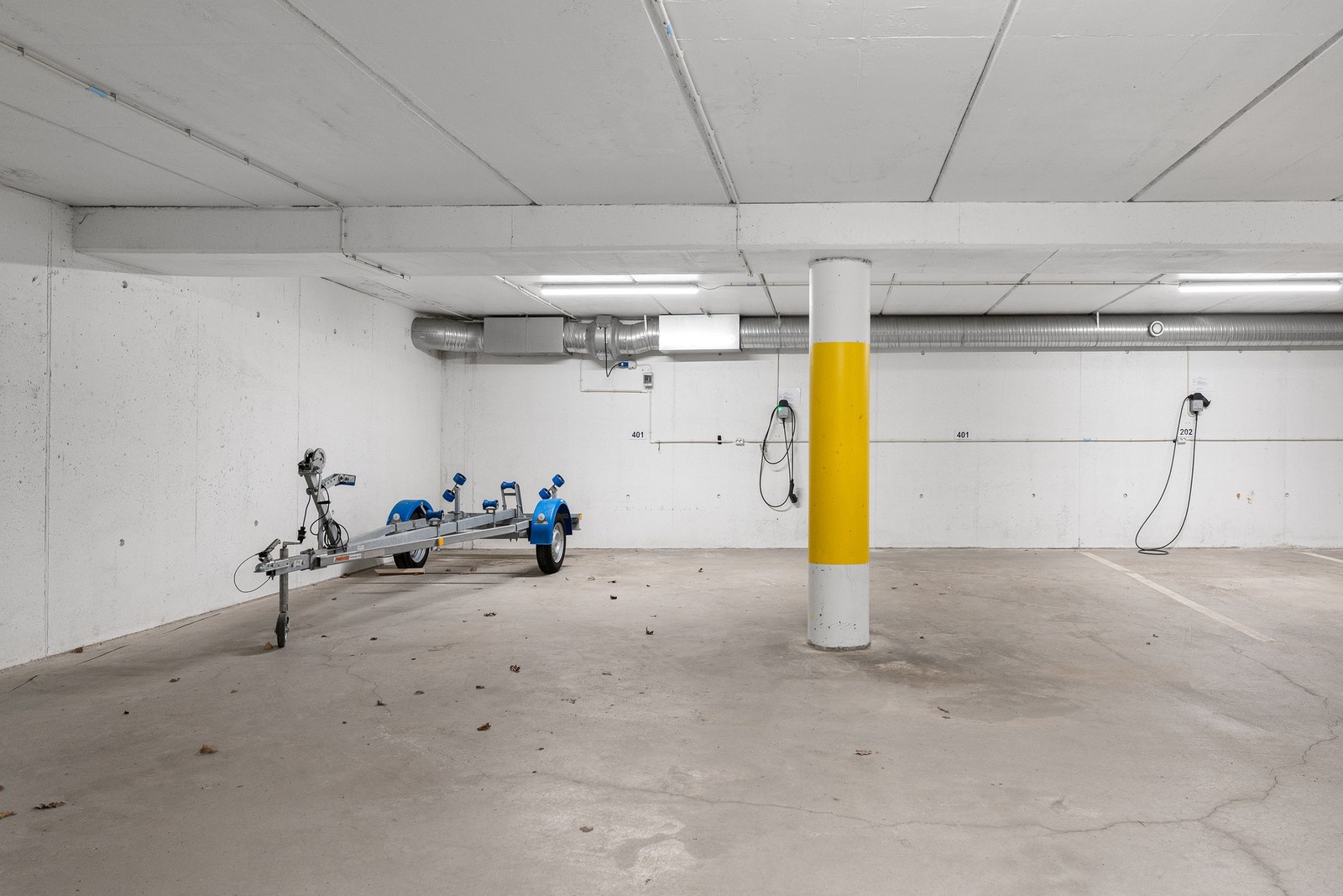 2 parkeringsplasser, nr 401, den til venstre er ekstra bred. Det er 1 el-bil lader på den venstre plassen. Galleribilde