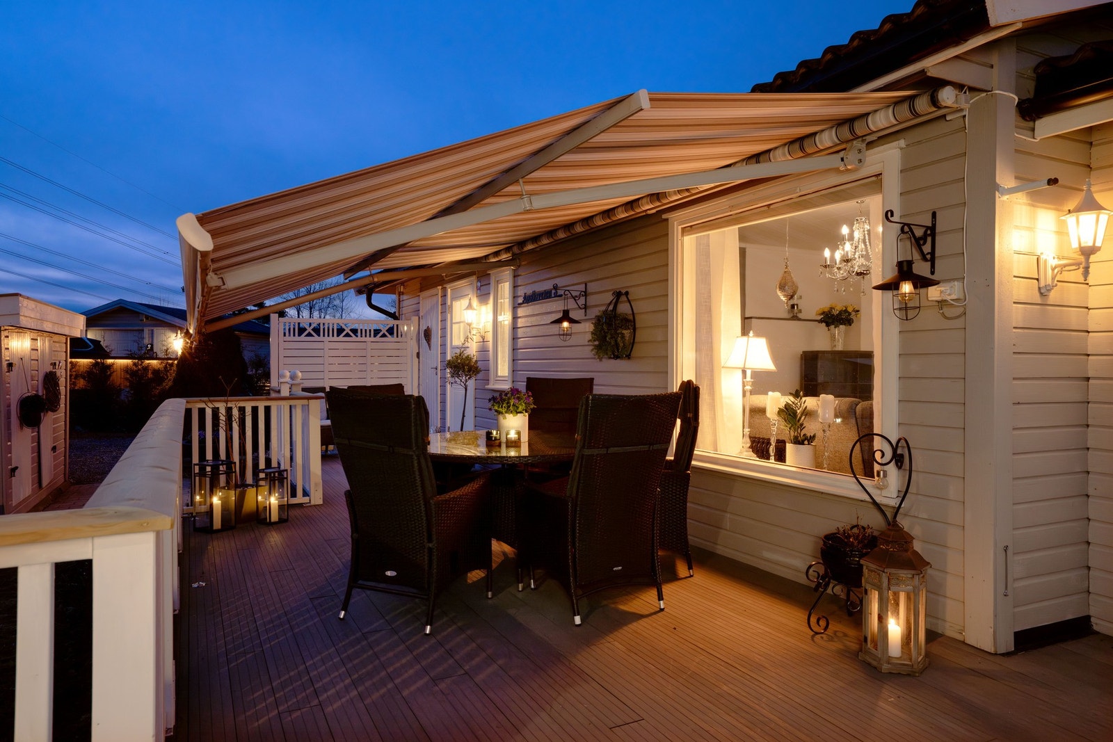 Terrasse i front med stor terrassemarkise og adkomst til utestuen. Galleribilde