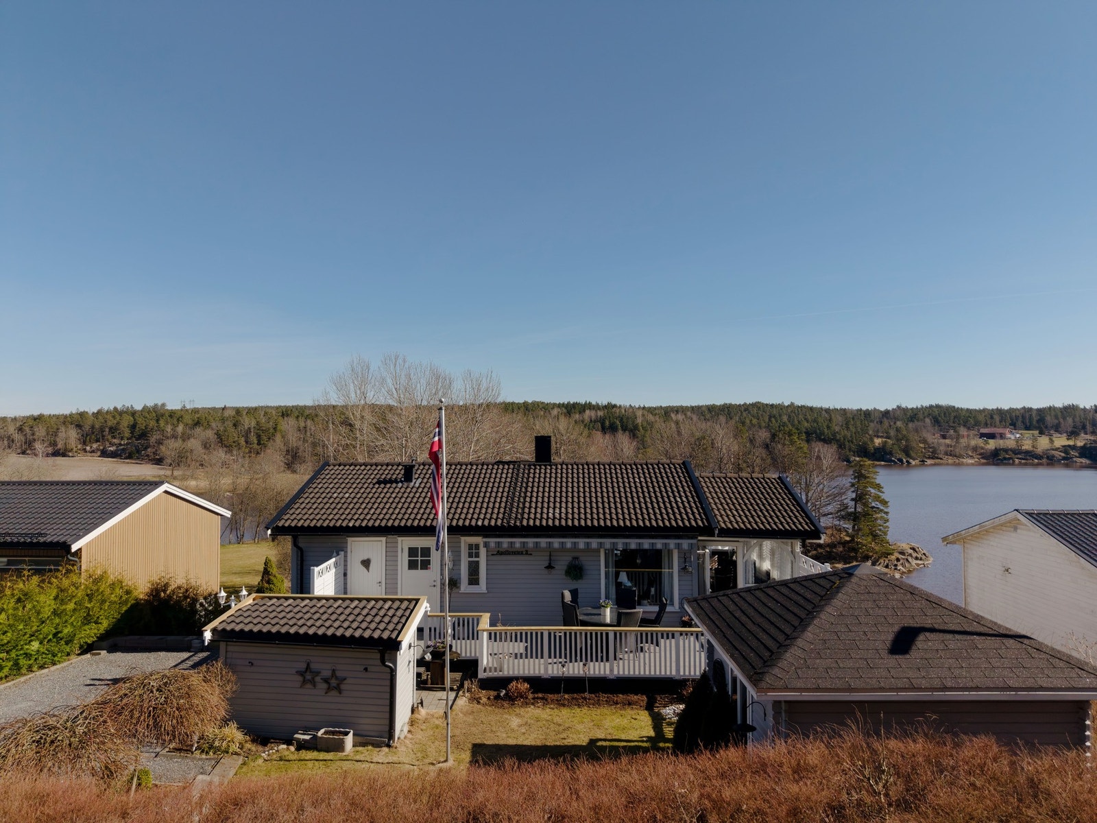Fasade front. Stor terrasse mot vest og terrassemarkise med støtteben. Galleribilde