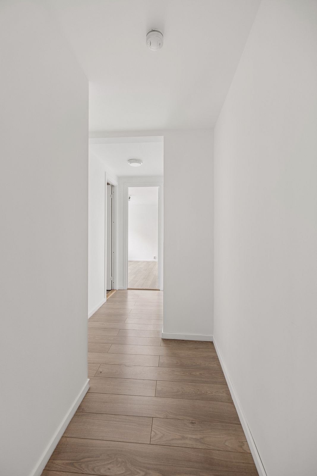 Fra entreen er det en egen gang som fører deg til leilighetens stue og soverom 1. Galleribilde