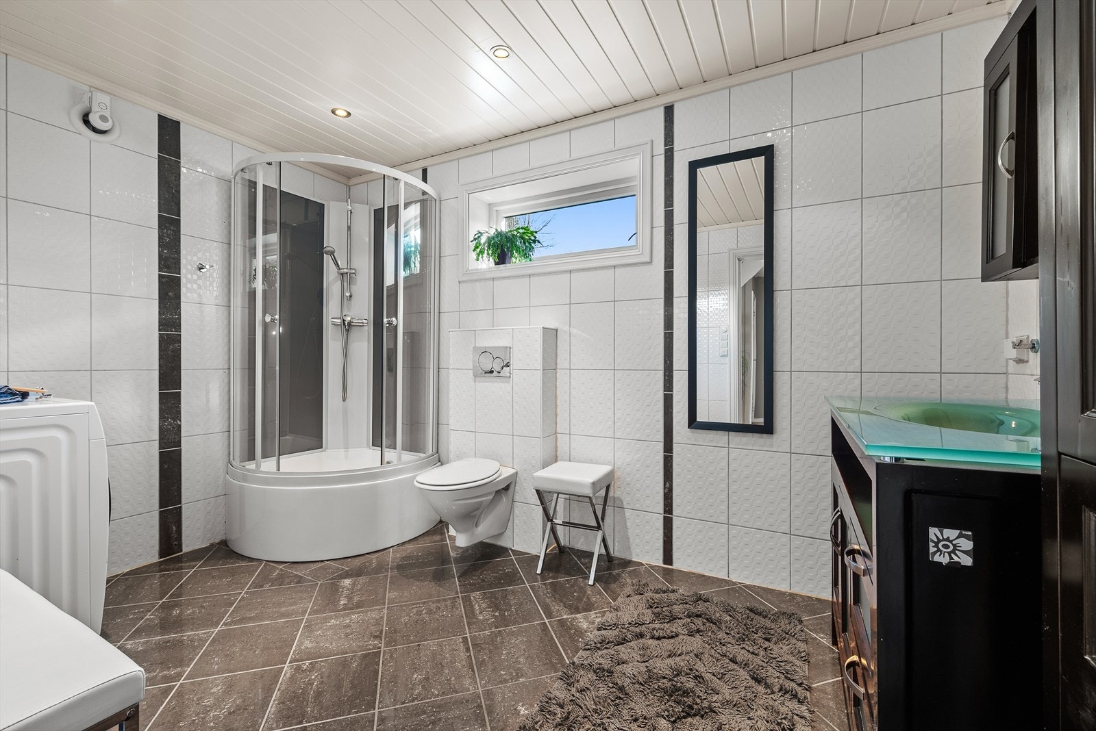 Utstyrt med dusjkabinett, servantskap, veggmontert wc, opplegg for vaskemaskin og mekanisk avtrekk. Galleribilde