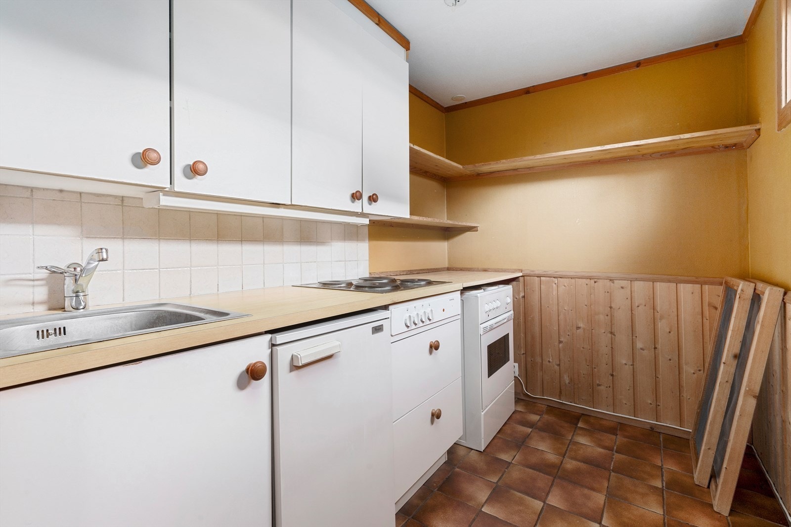 Kjøkkenet har innredning med glatte fronter. Benkeplaten er av laminat og nedfelt stålkum. Fliser over deler av benk. . Det er platetopp i benkeplaten. Galleribilde