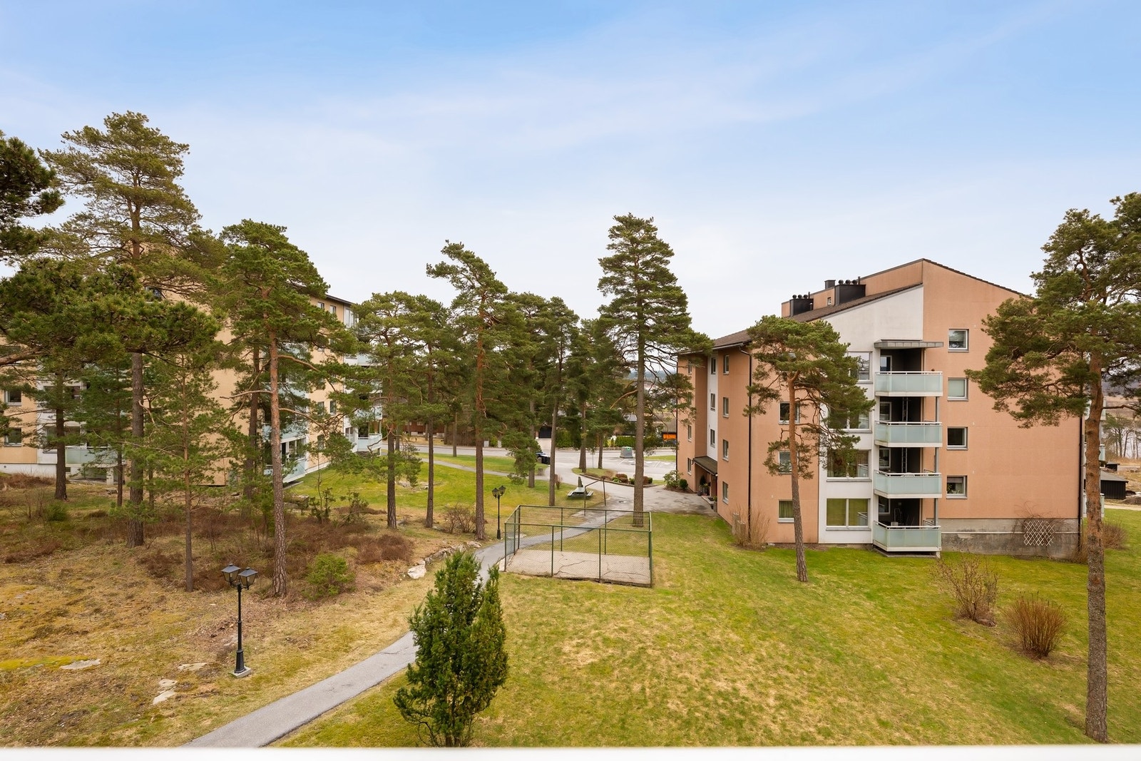 Hyggelig felles uteområde med fin blanding av naturtomt, gressplen og furutrær. Det er ladestasjoner til el-biler i borettslaget. Galleribilde