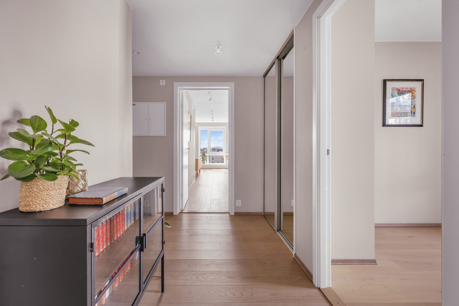 Entréen har god plass til oppbevaring av yttertøy og sko i en praktisk skyvedørsgarderobe med speilfronter Galleribilde