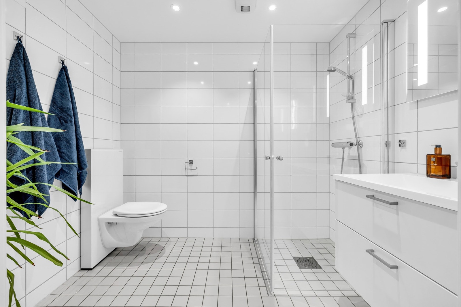 ovedbadet har adkomst fra entréen og er praktisk innredet med servantinnredning med skuffer, toalett og dusj. Her er det i tillegg opplegg for vaskemaskin Galleribilde