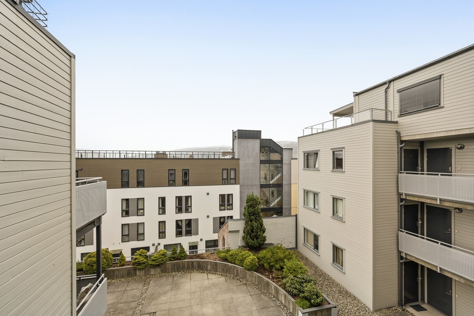 Utsikt mot et velholdt og pent opparbeidet atrium. Galleribilde