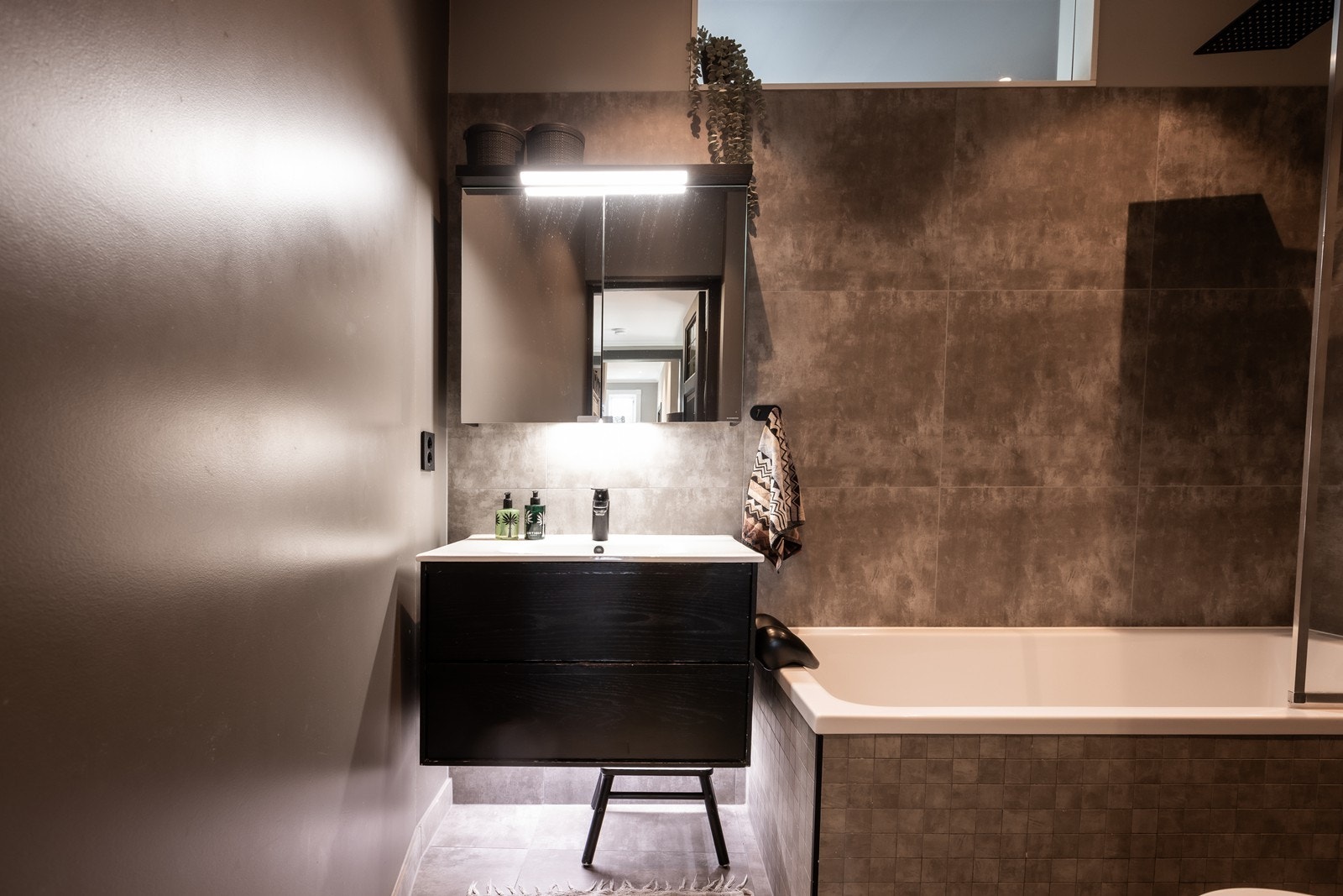Bad/wc som ble pusset opp i 2020. Badet har flislagt gulv med varmekabler, innfliset badekar, veggmontert toalett, servantskap med glatte, folierte fronter og heldekkende servant. Galleribilde