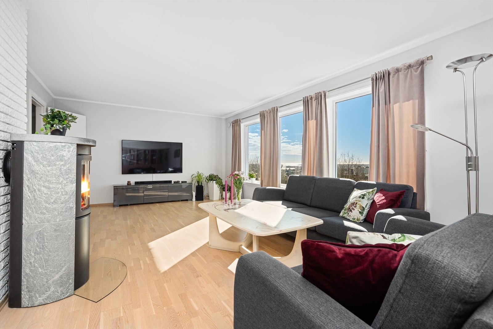 I stuen er det lyst og trivelig med naturlig dagslys som kommer inn fra de store vindusflatene. Det er lagt parkettgulv, samt satt inn en rentbrennende vedovn. Galleribilde