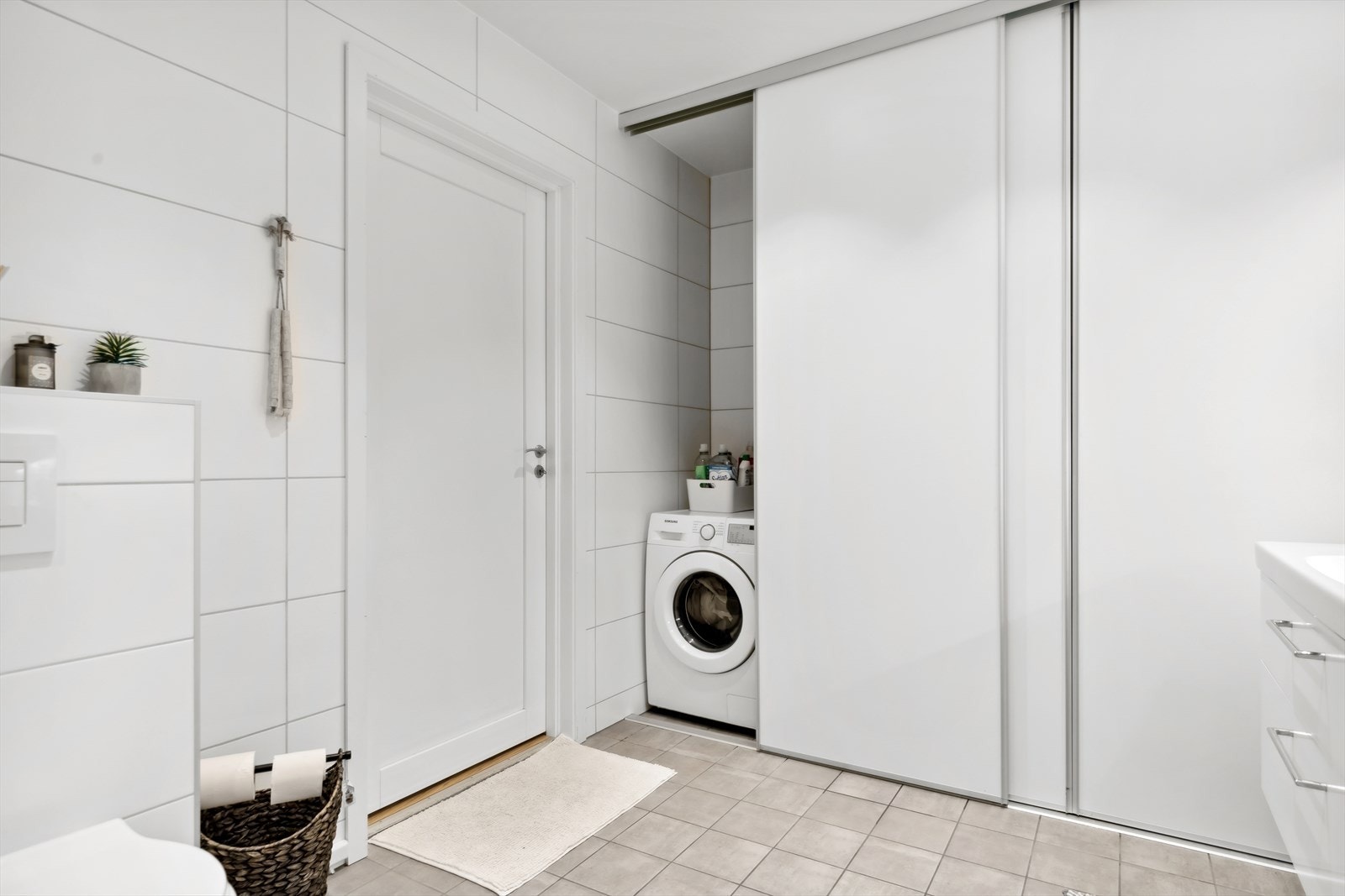 Badet har plass til vaskemaskin og praktisk oppbevaring bak skyvedører. Galleribilde