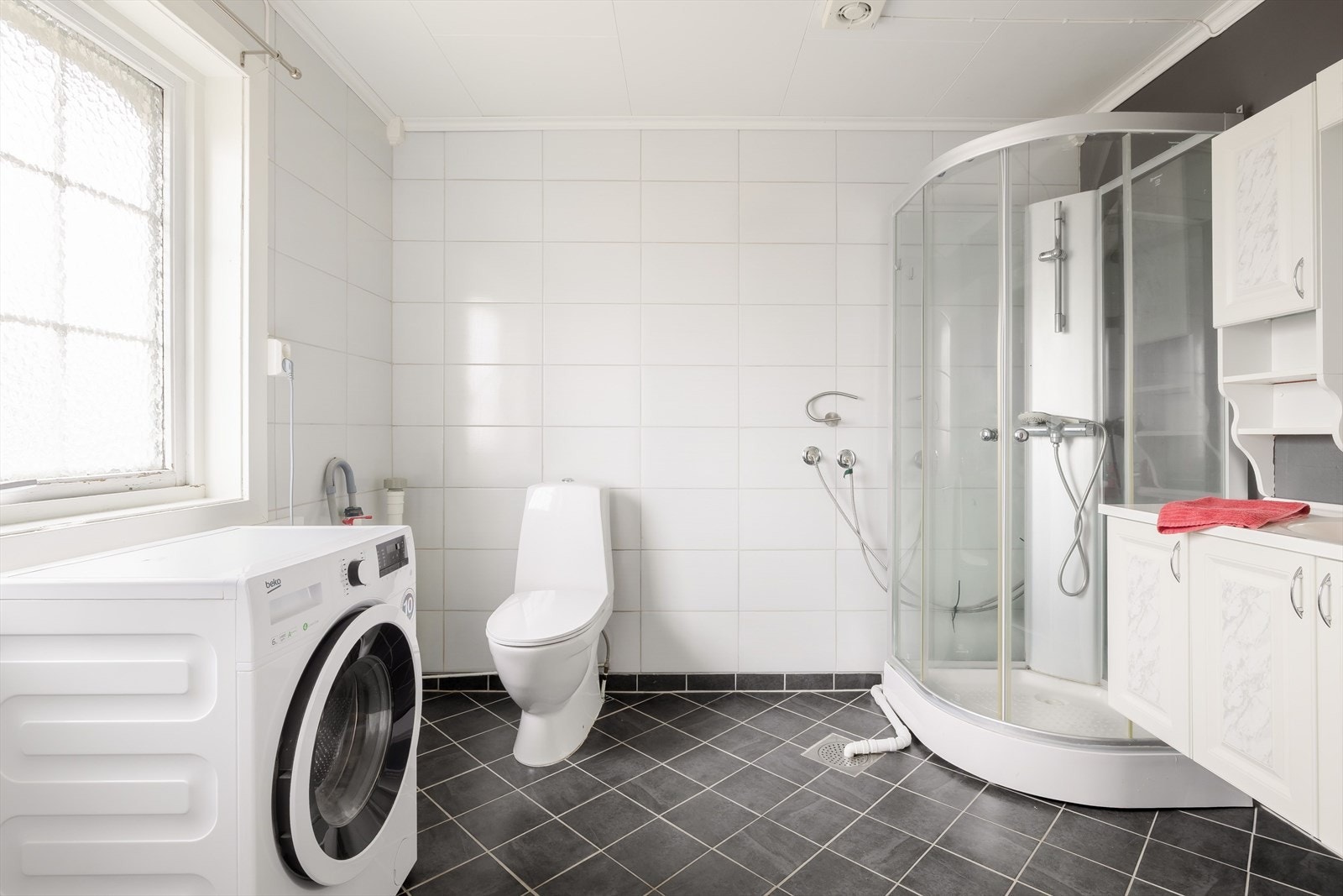 Badet ble oppgradert i 2016. Rommet har flislagte veggflater og gulv. Badet er utstyrt med vegghengt servantinnredning med ovenpåliggende servant og armatur, speil med overlys, dusjkabinett, gulvstående toalett og opplegg for vaskemaskin. Galleribilde