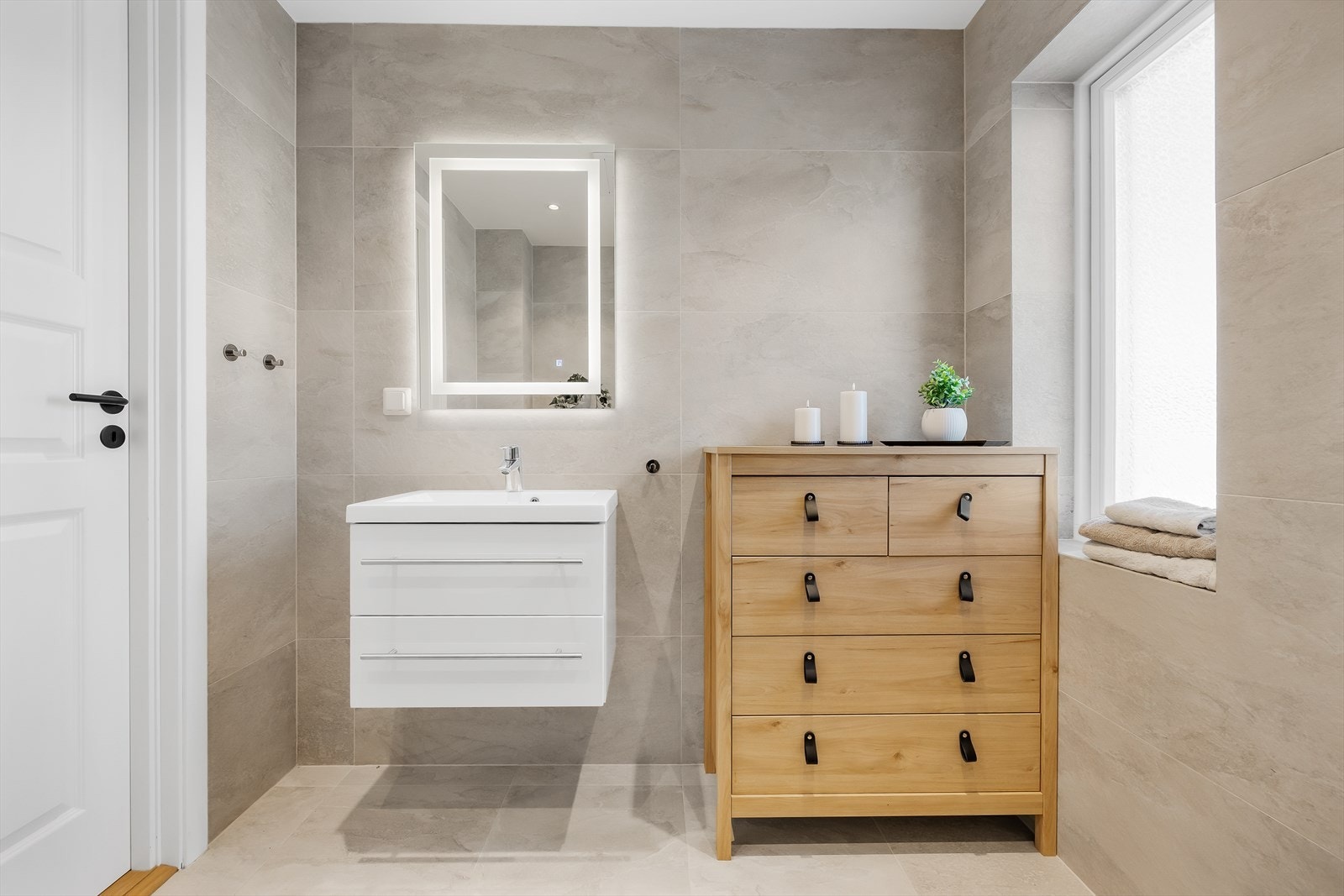 Badet er innredet med servantskap og speil med integrert belysning. Galleribilde