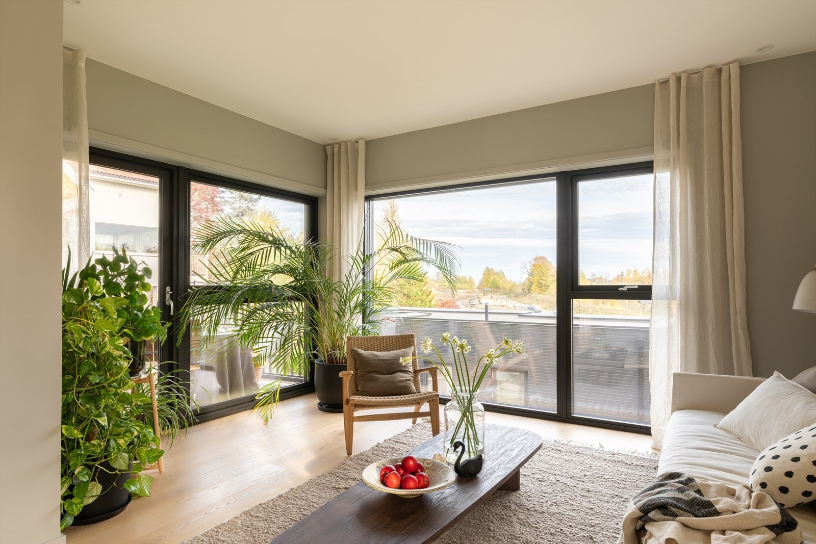 Årstidene kommer tett på, og vinduer til gulvet inkluderer en glassdør til den flislagte terrassen. Dagslyset i stuen suppleres fint av spotter i taket, og et lyst 1-stavs parkettgulv står godt til duse vegger. Galleribilde