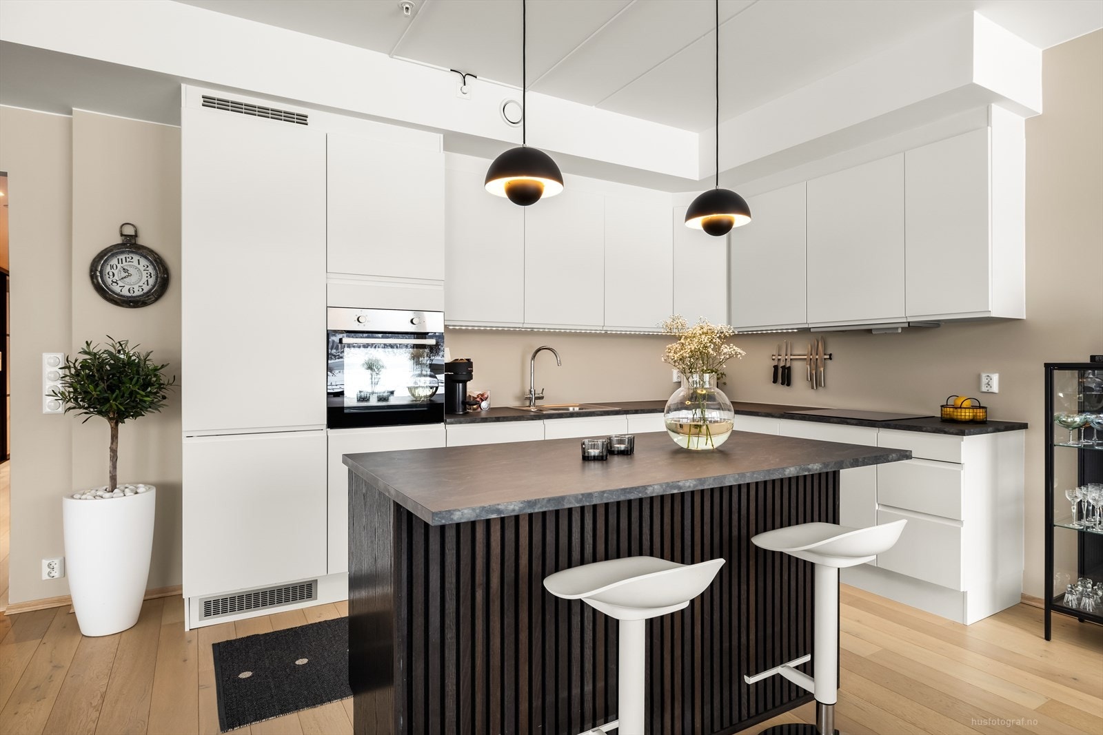 Stilren kjøkkeninnredning levert av Designa, med overflater som består av hvite glatte fronter og benkeplate av laminat. Galleribilde