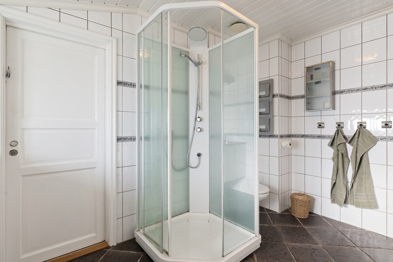 Rommet inneholder også et veggmontert toalett og et praktisk dusjkabinett. Galleribilde