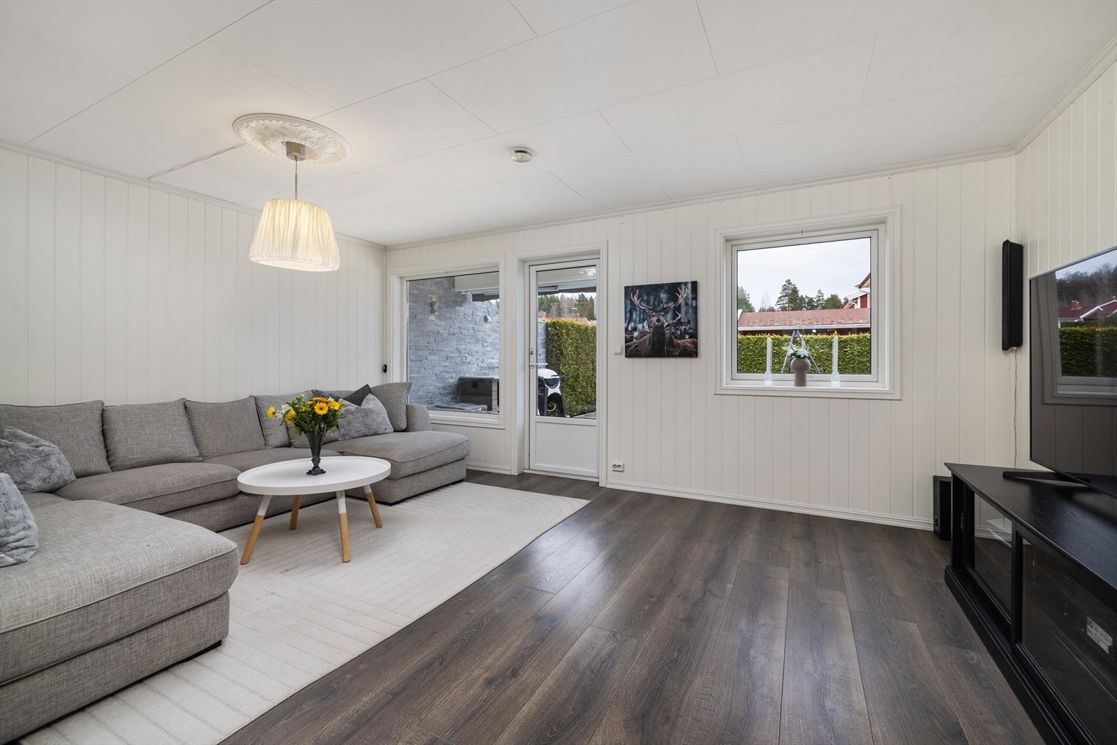 Terrassedøren i stuen åpner opp mot den store uteplassen mot sør. Galleribilde