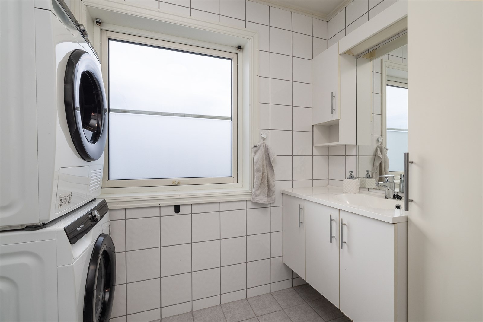 Badet fungerer også som vaskerom med praktisk opplegg for vaskemaskin. Galleribilde