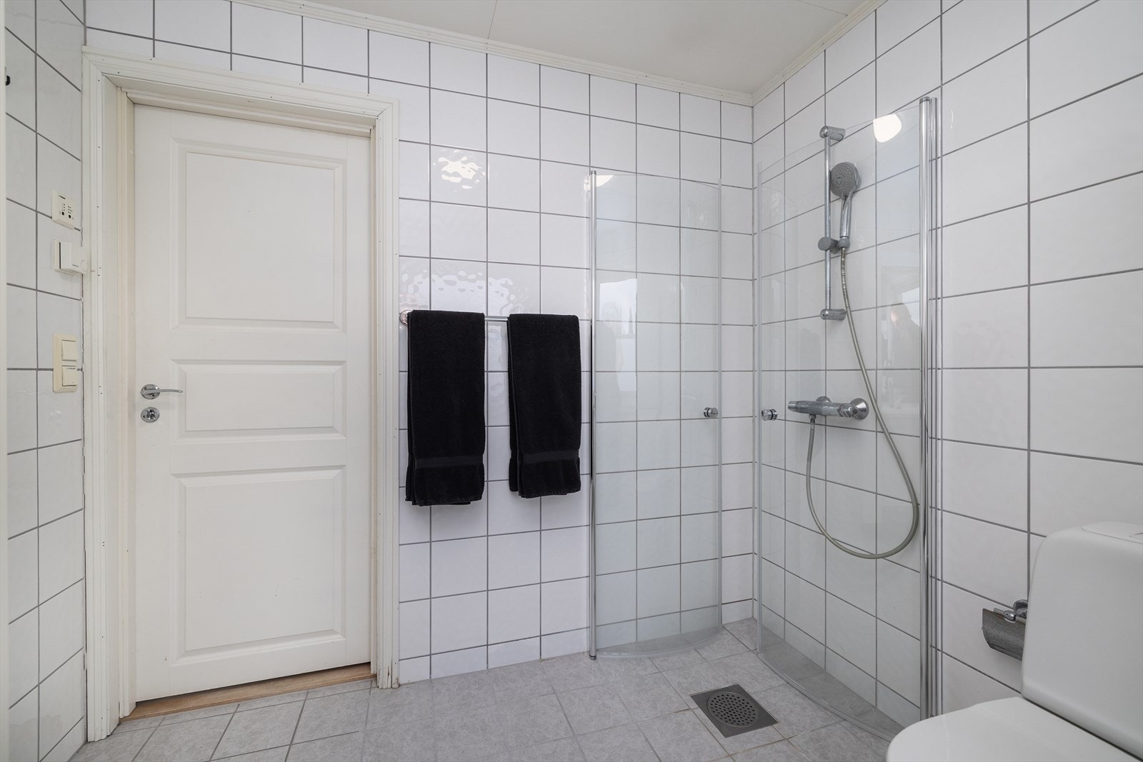Badet i andre etasje er flislagt og utstyrt med dusjhjørne med glassdører. Galleribilde