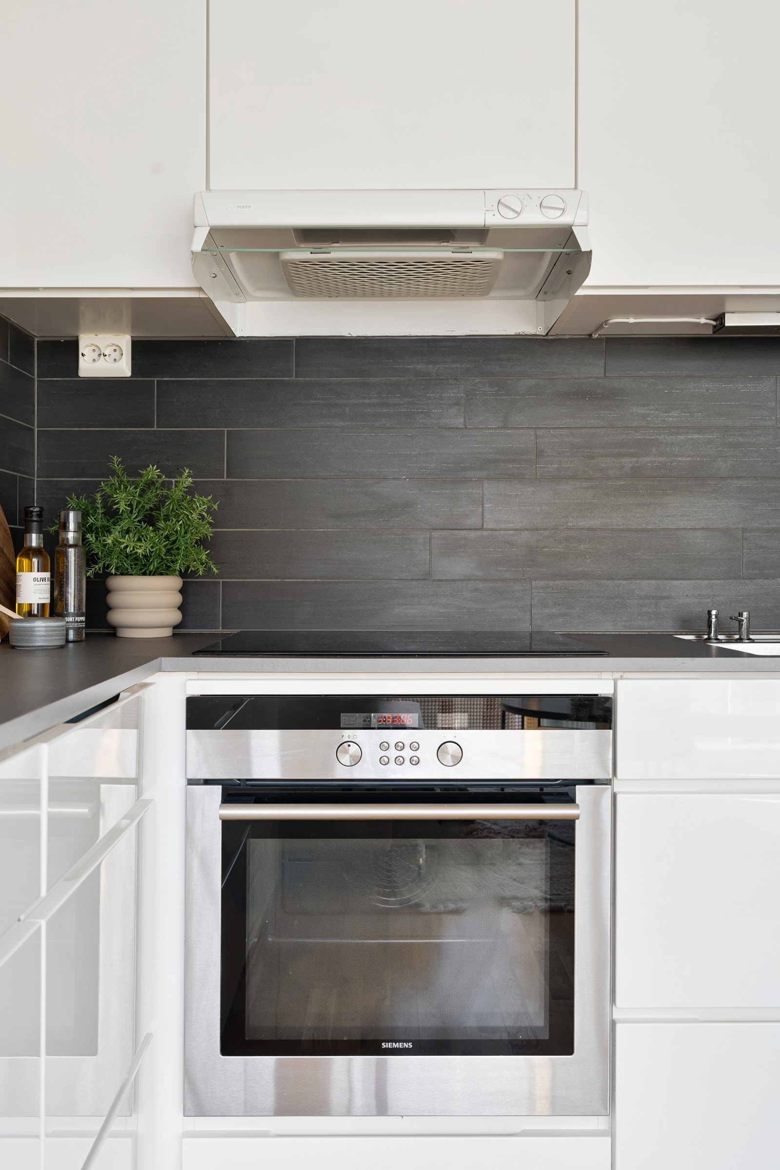 Kjøkkenet er utstyrt med integrerte hvitevarer som kjøl/fryseskap, oppvaskmaskin, induksjonstopp og stekeovn.