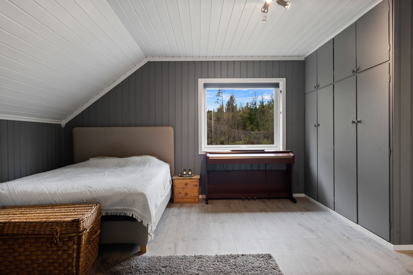 Hovedsoverommet har plassbygde skap og utsikt i mot den koselige skogen i bakkant av boligen Galleribilde