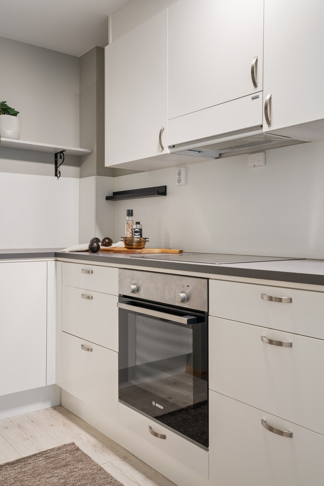 Kjøkkeninnredningen fra byggeåret har hvite, glatte fronter og en solid laminat benkeplate. Galleribilde