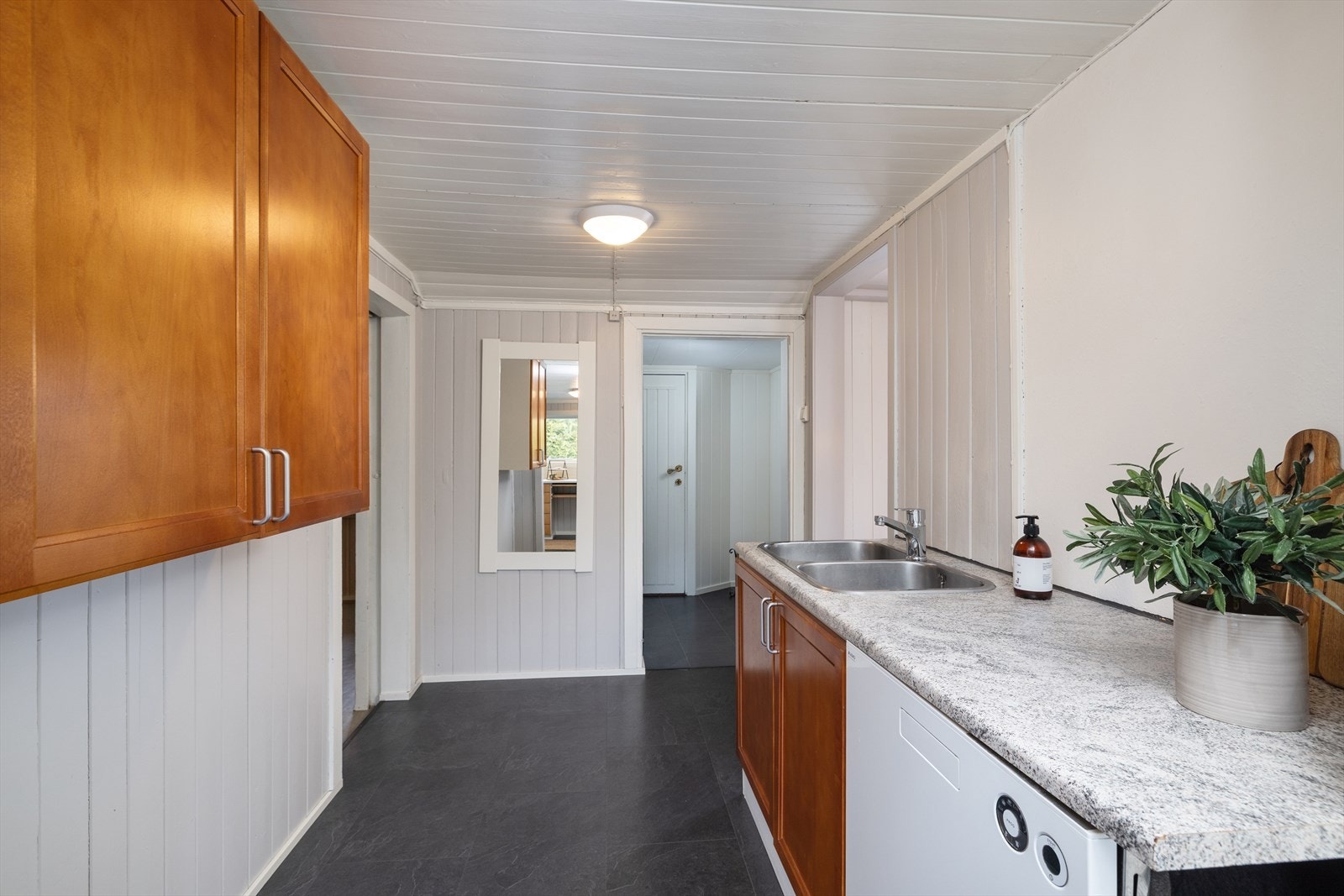 Kjøkkeninnredningen har laminat benkeplate og dobbel stålkum. Det er tilrettelagt for frittstående hvitevarer og opplegg for oppvaskmaskin. Galleribilde
