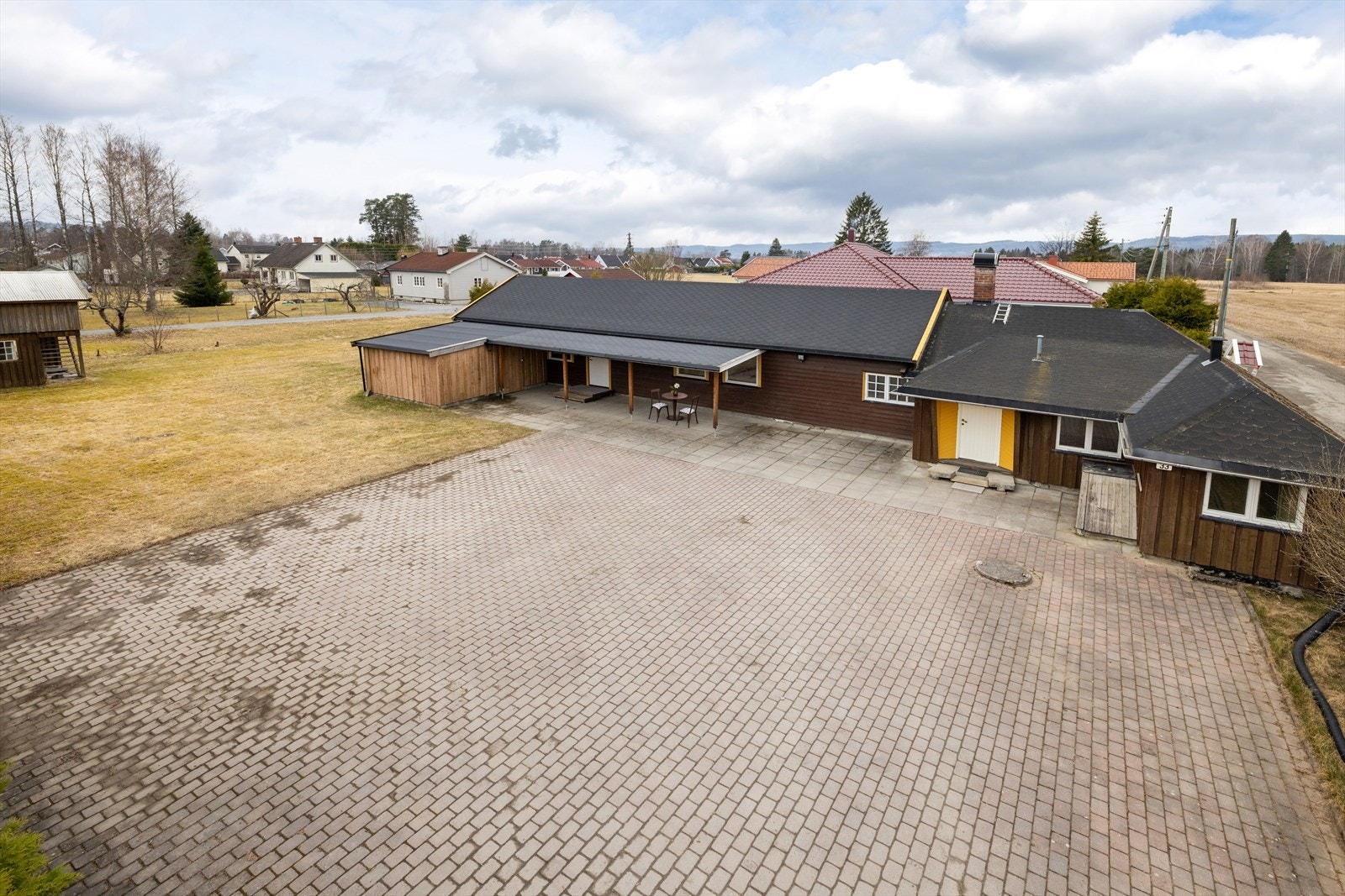 Stor gårdsplass, hellelagt gårdsplass og et takoverbygget inngangsparti på 24 m². Galleribilde