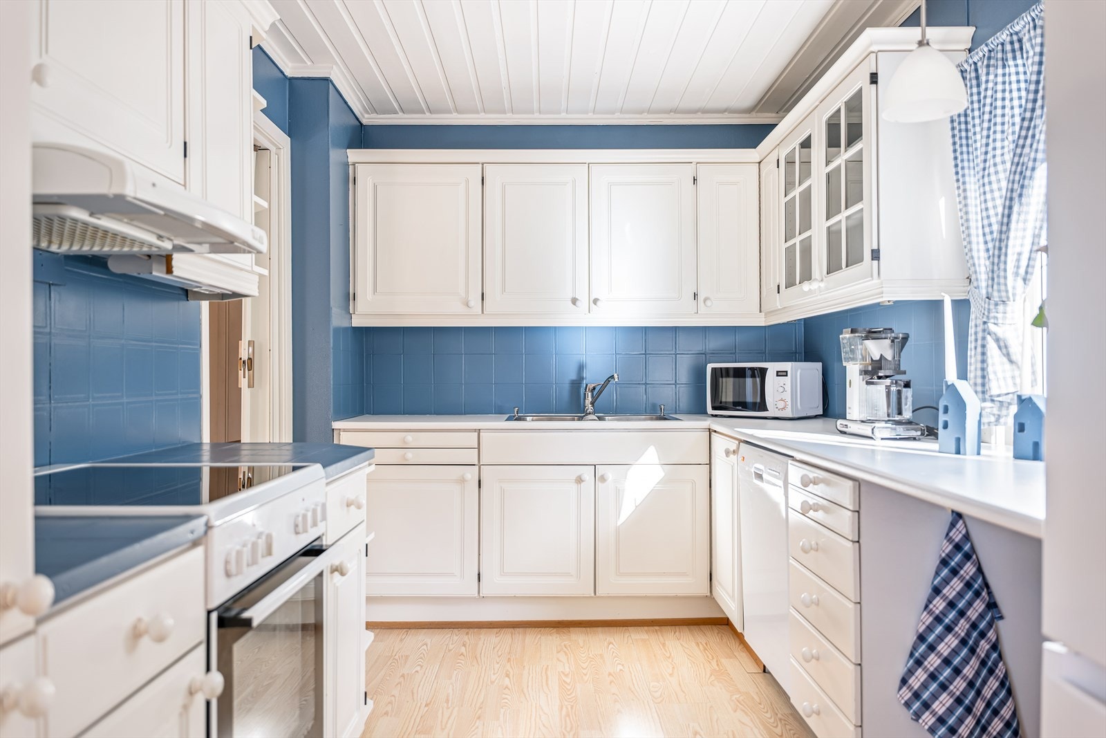 Kjøkkeninnredning med malte profilerte froner og laminat benkeplate med nedfelt kum Galleribilde