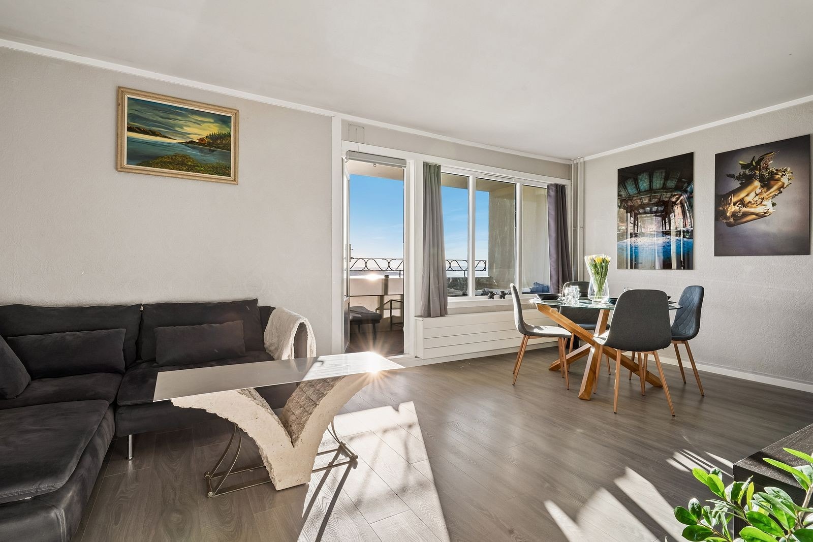 Romslig stue med sofa og spisebord. Fra stuen er det utgang til flott balkong. Galleribilde