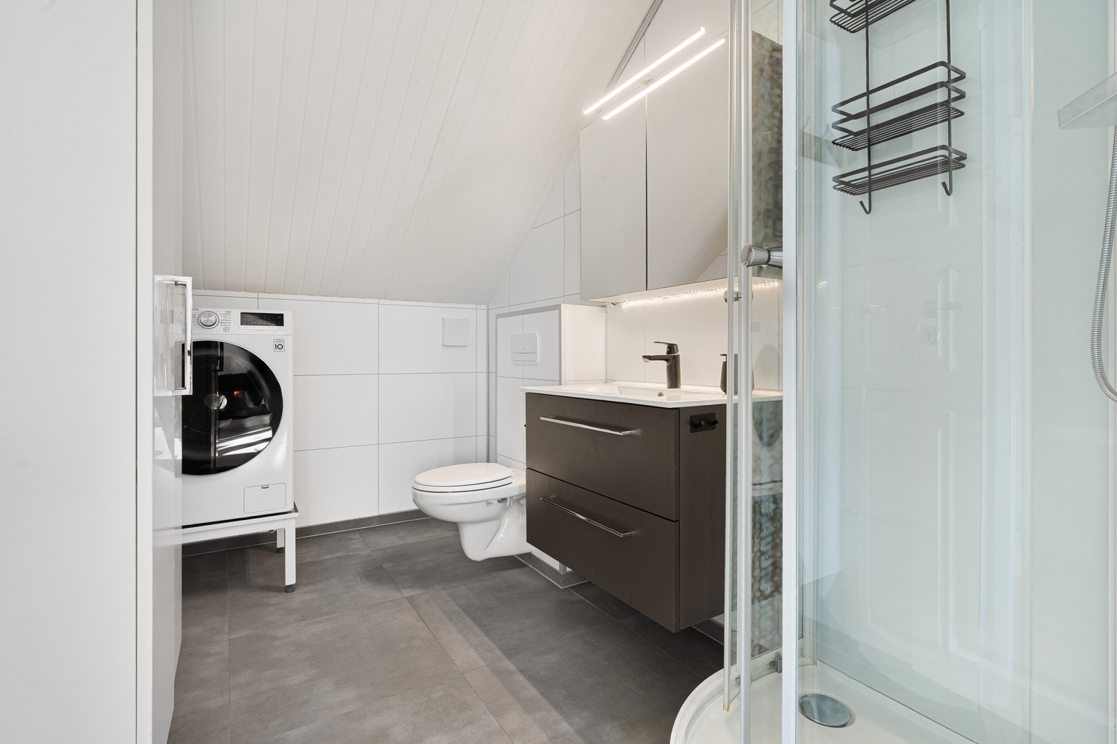 Tiltalende baderom med plass til alle dagligdagse gjøremål med opplegg til vaskemaskin.