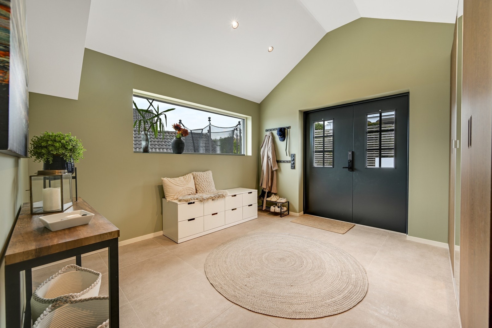 Innbydende entré med imponerende takhøyde, elegant dobbeldør og store vindusflater som slipper inn rikelig med naturlig lys. Galleribilde