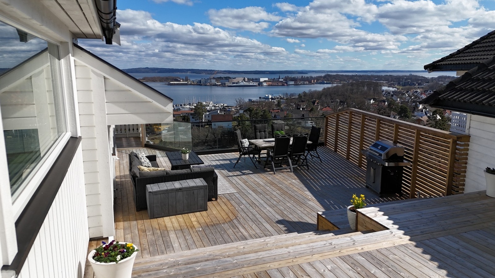 Stor, solrik hovedterrasse med flere soner for spisegruppe og lounge - alt med fantastisk panoramautsikt over fjorden. Galleribilde