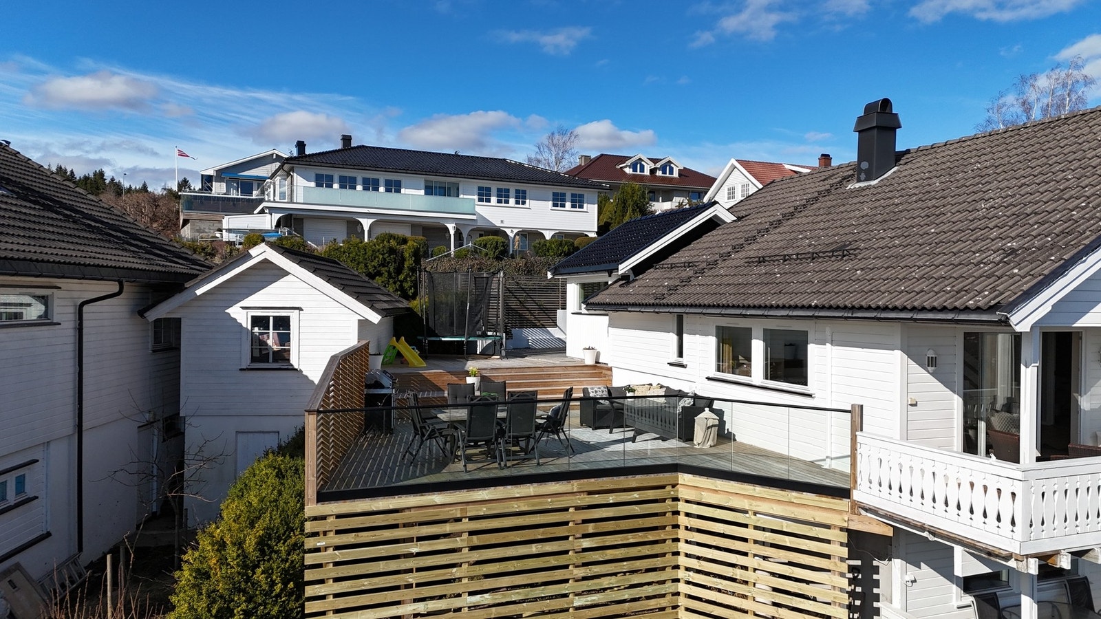 Eiendommen har en stor, skjermet terrasse med flere soner for både spiseplass, avslapning og lek - perfekt tilpasset hyggelige dager ute med familie og venner. Galleribilde