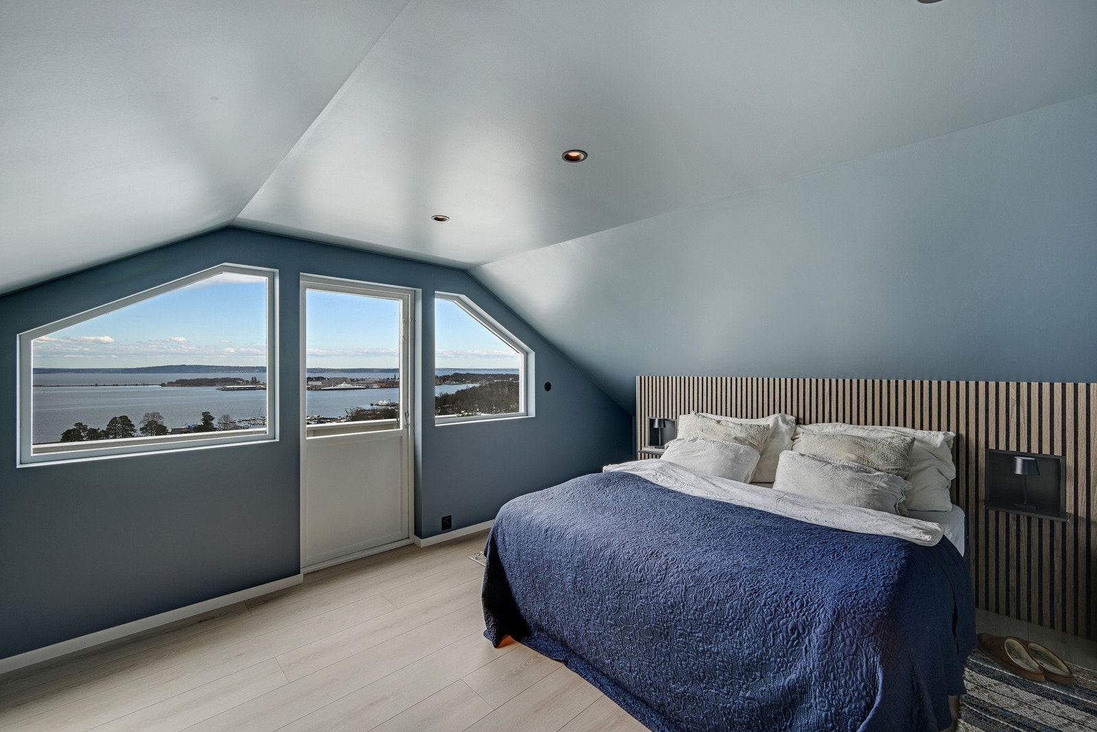 Eksklusivt hovedsoverom (ikke omsøkt) i loftsetasjen med spektakulær sjøutsikt, lun atmosfære og direkte utgang til privat balkong. Galleribilde