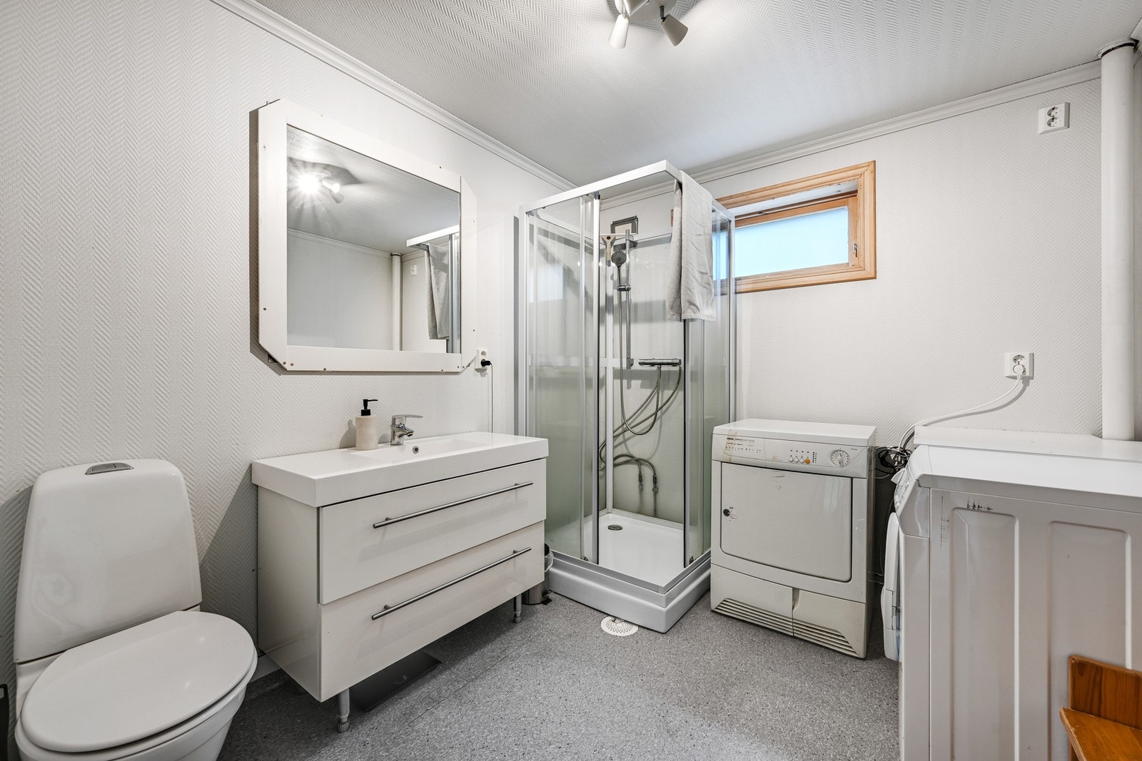Badet i underetasjen er romslig og funksjonelt innredet med dusjkabinett, wc, servant med innredning og opplegg for vaskemaskin. Galleribilde